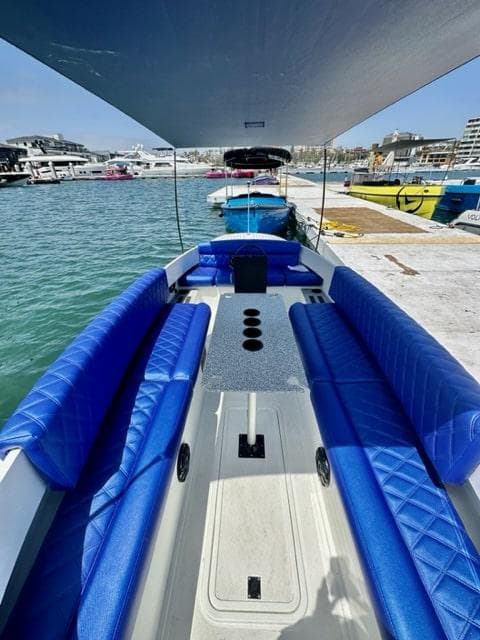 2023 Vision Marine Technologies Fantail 217 boat with blue seating at a marina.