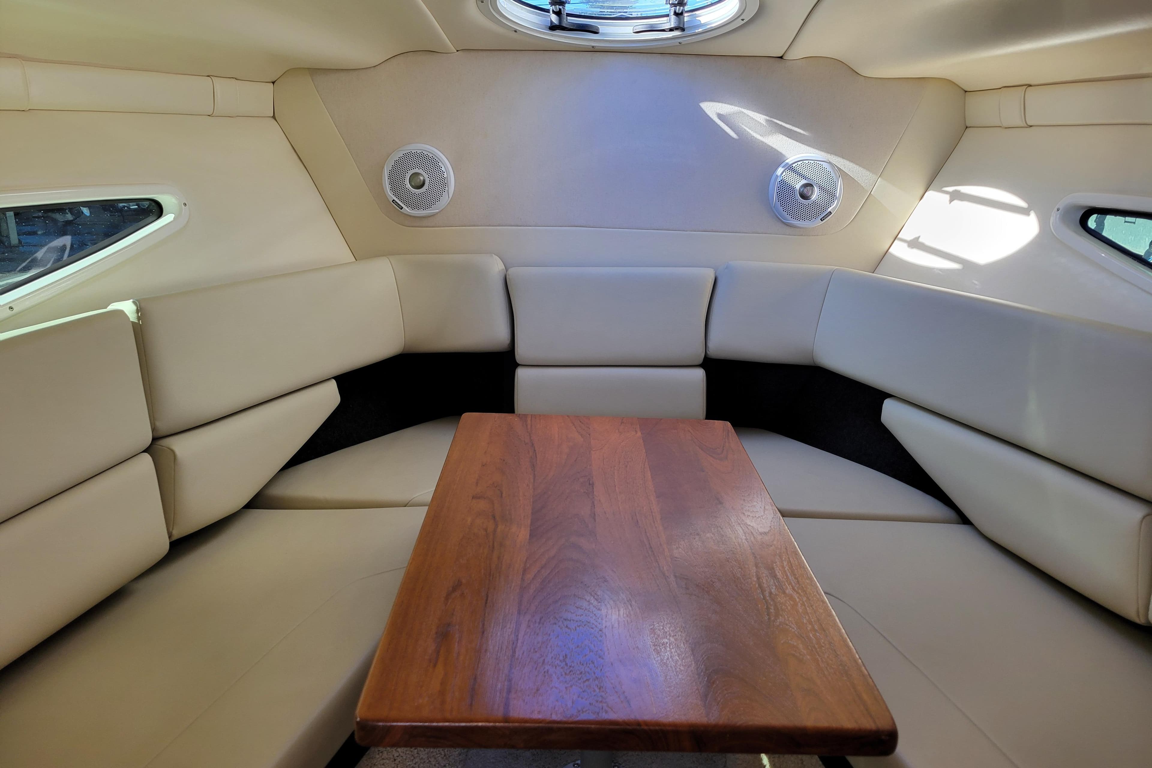 Interior of 2018 Regal 26 Express boat with beige seating and wooden table.