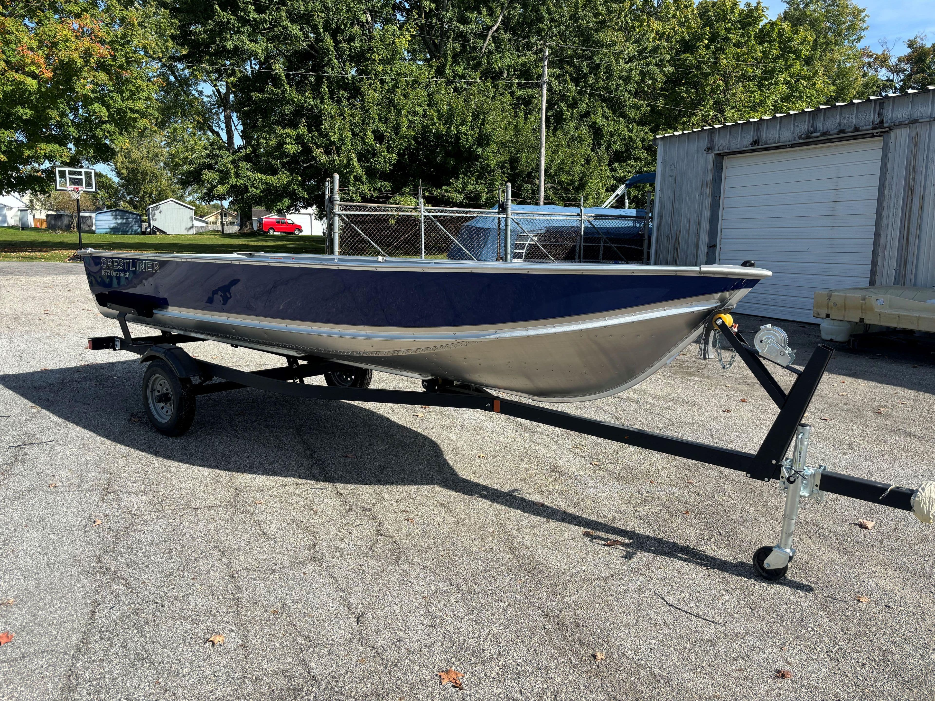 2025 Crestliner 1672 Outlook boat on trailer in outdoor setting.
