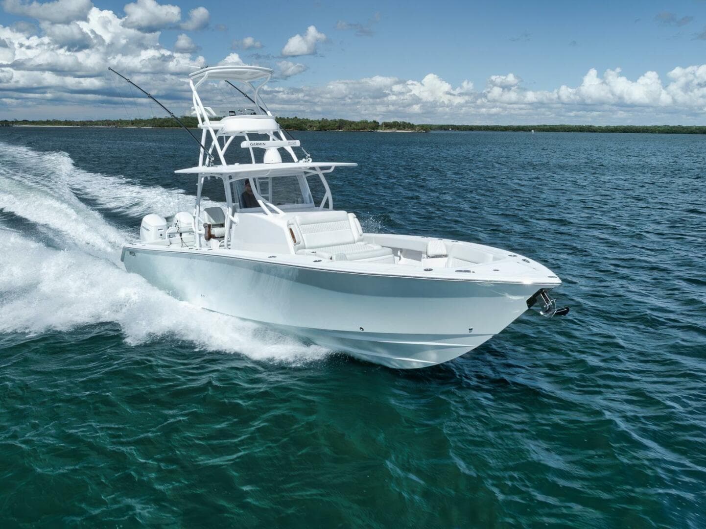 2023 Jupiter 40 boat cruising on clear blue water under a partly cloudy sky.