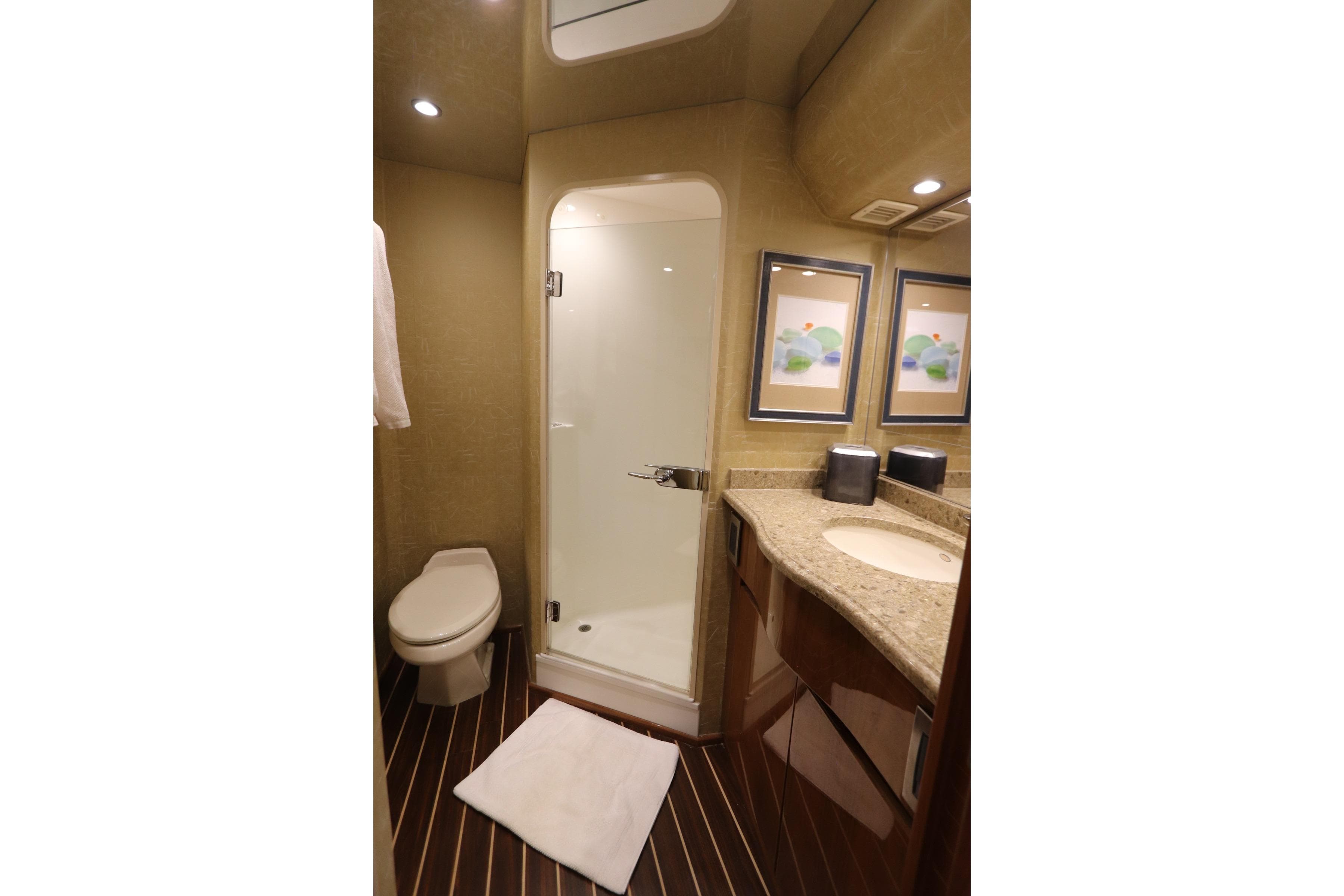 Luxurious bathroom in 2013 Viking 66 yacht with shower, toilet, and elegant vanity.