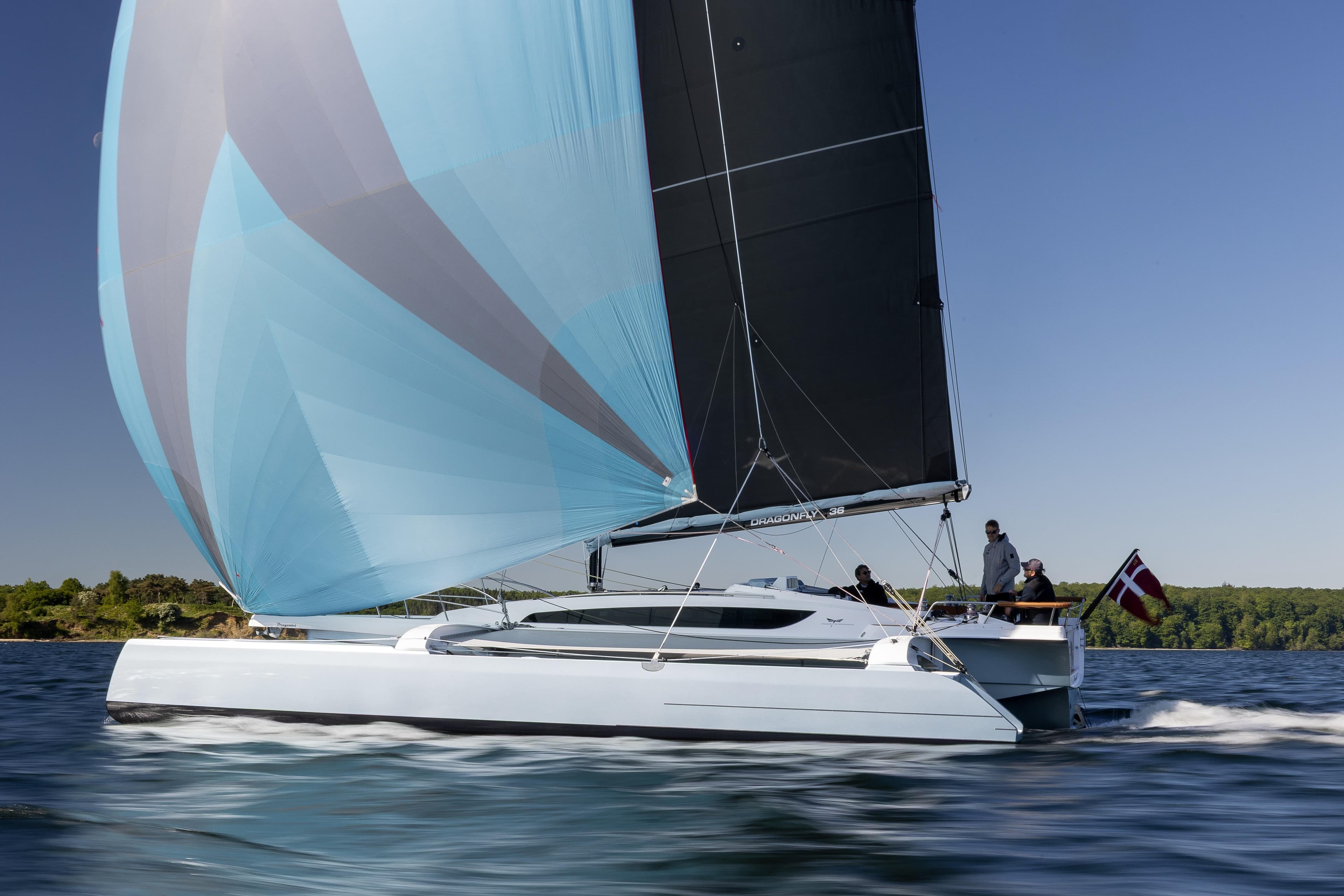 Sleek 2027 Dragonfly 36 sailboat gliding on water with vibrant sails.