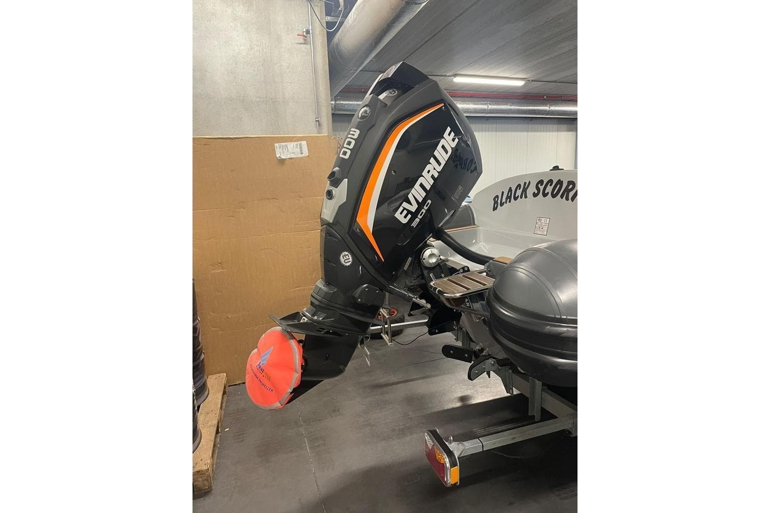 2018 Infanta 7.5 SR boat with Evinrude 300 outboard motor in a garage.