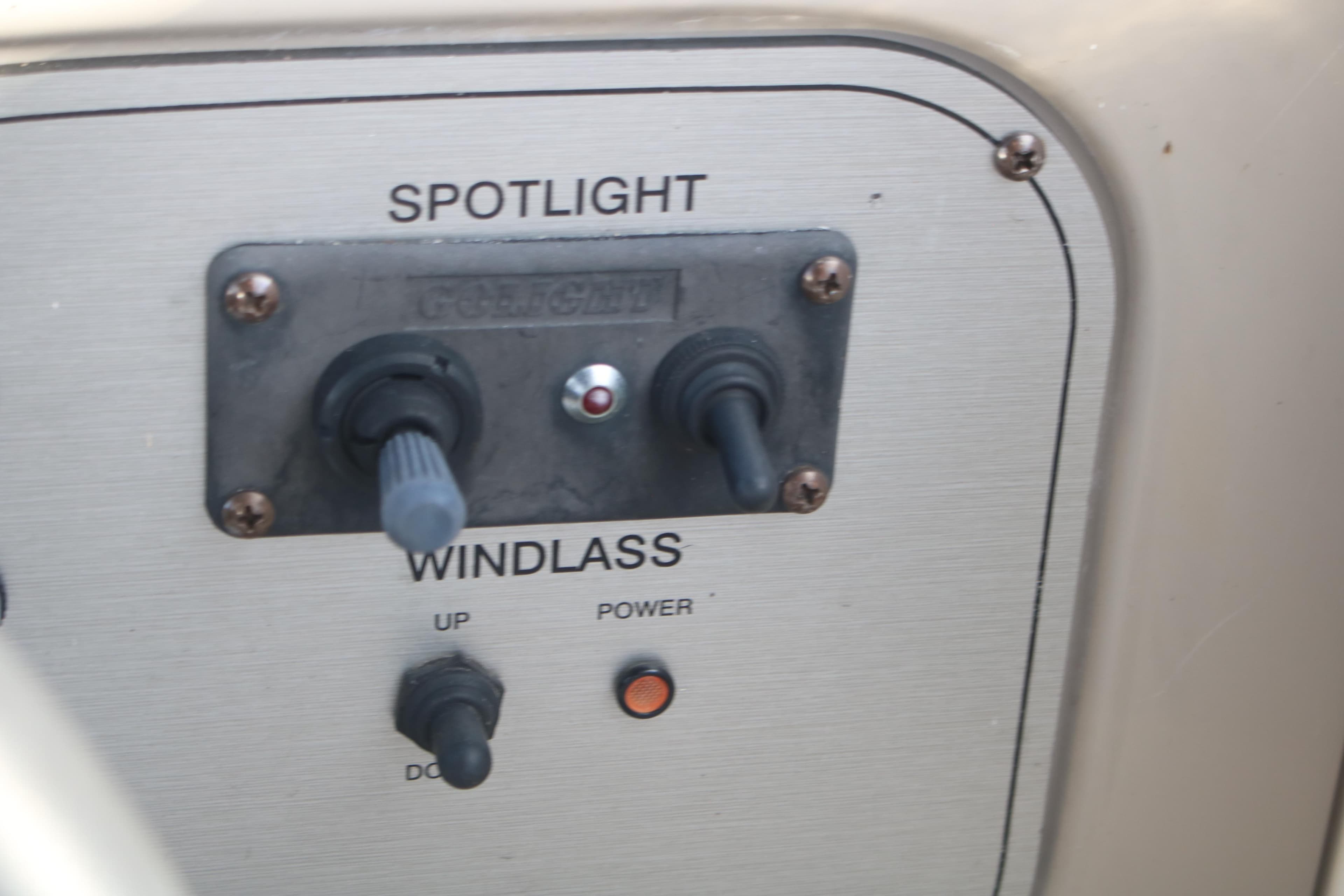 Control panel of a 2011 Larson Carbiro 240 boat featuring spotlight and windlass switches.