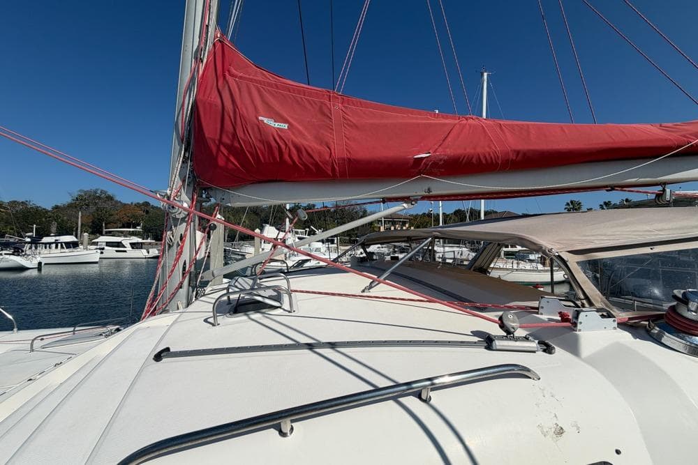 Sailing yacht Leopard 38, 2000 model, with red sail cover, docked in marina.