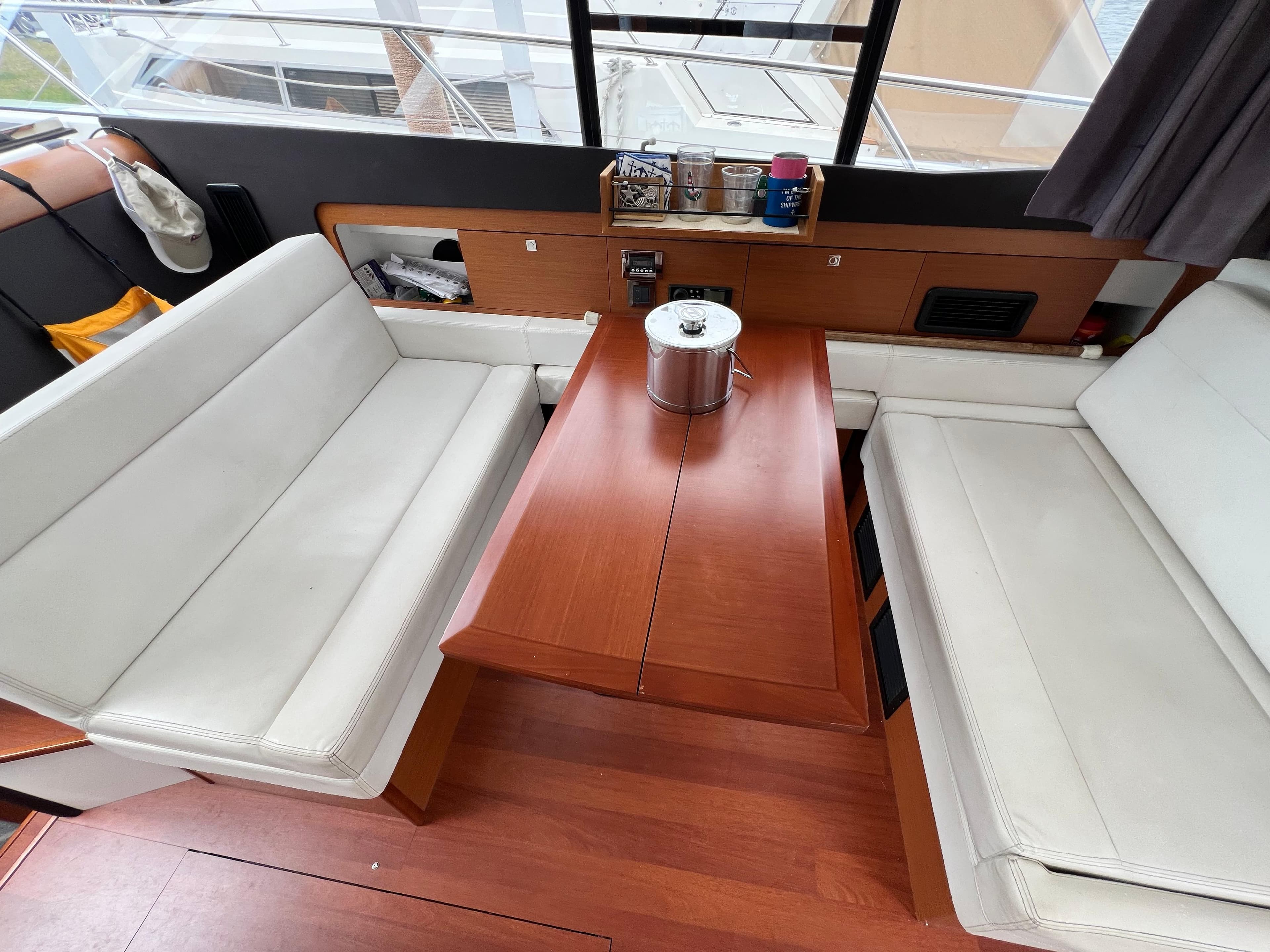 Interior of 2017 Jeanneau NC11 yacht with white seating and wooden table.