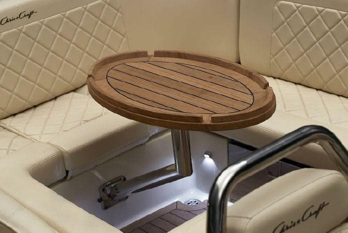 Luxurious interior of 2024 Chris-Craft Launch 27 with elegant wooden table and quilted seating.
