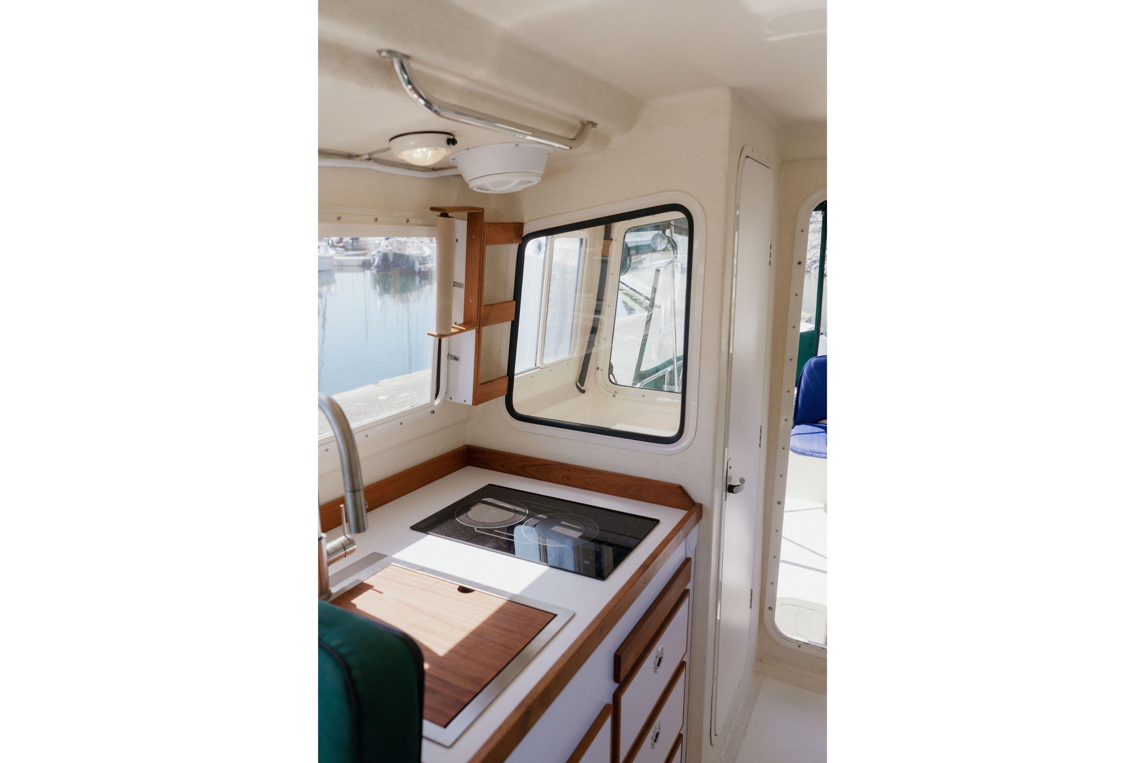 Interior of 2006 C-Dory 25' Tomcat Catamaran with kitchenette and window view.