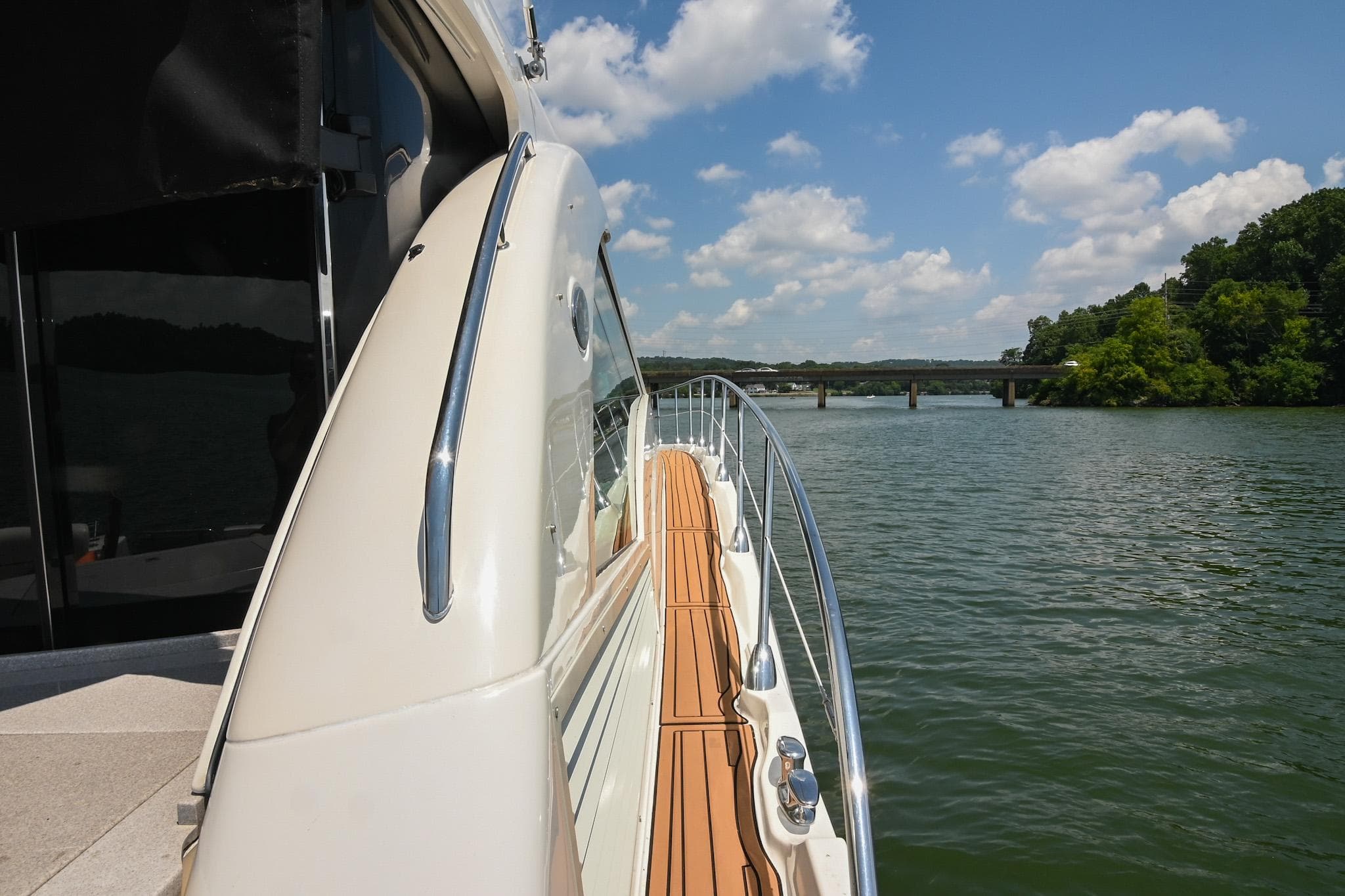 2007 Sea Ray 60 Sundancer yacht on a scenic river under a blue sky.