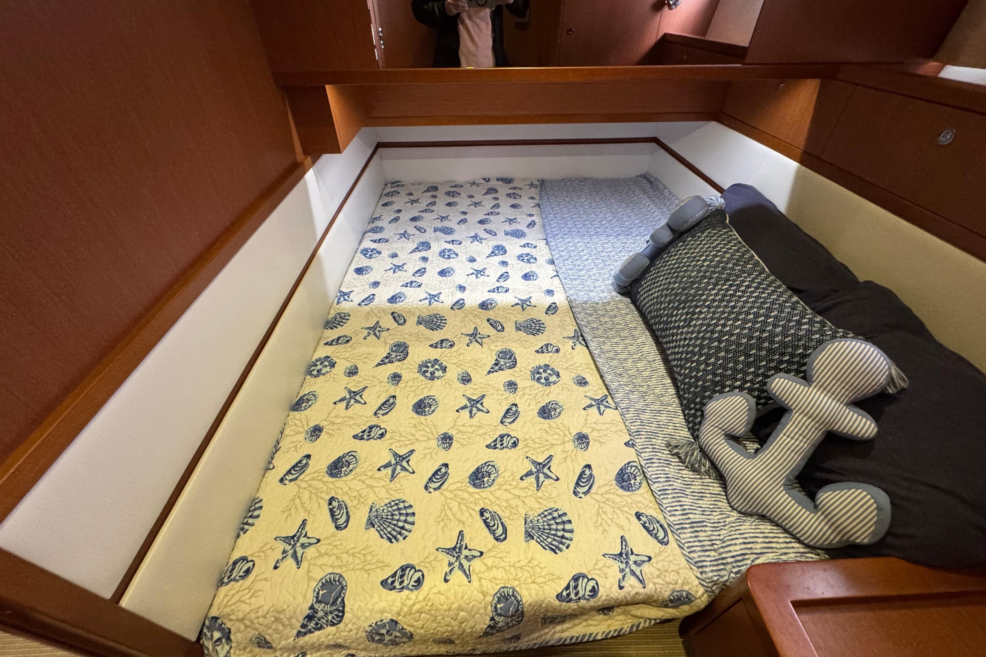 Cozy cabin bed in 2014 Beneteau Swift Trawler 44 with nautical-themed bedding.
