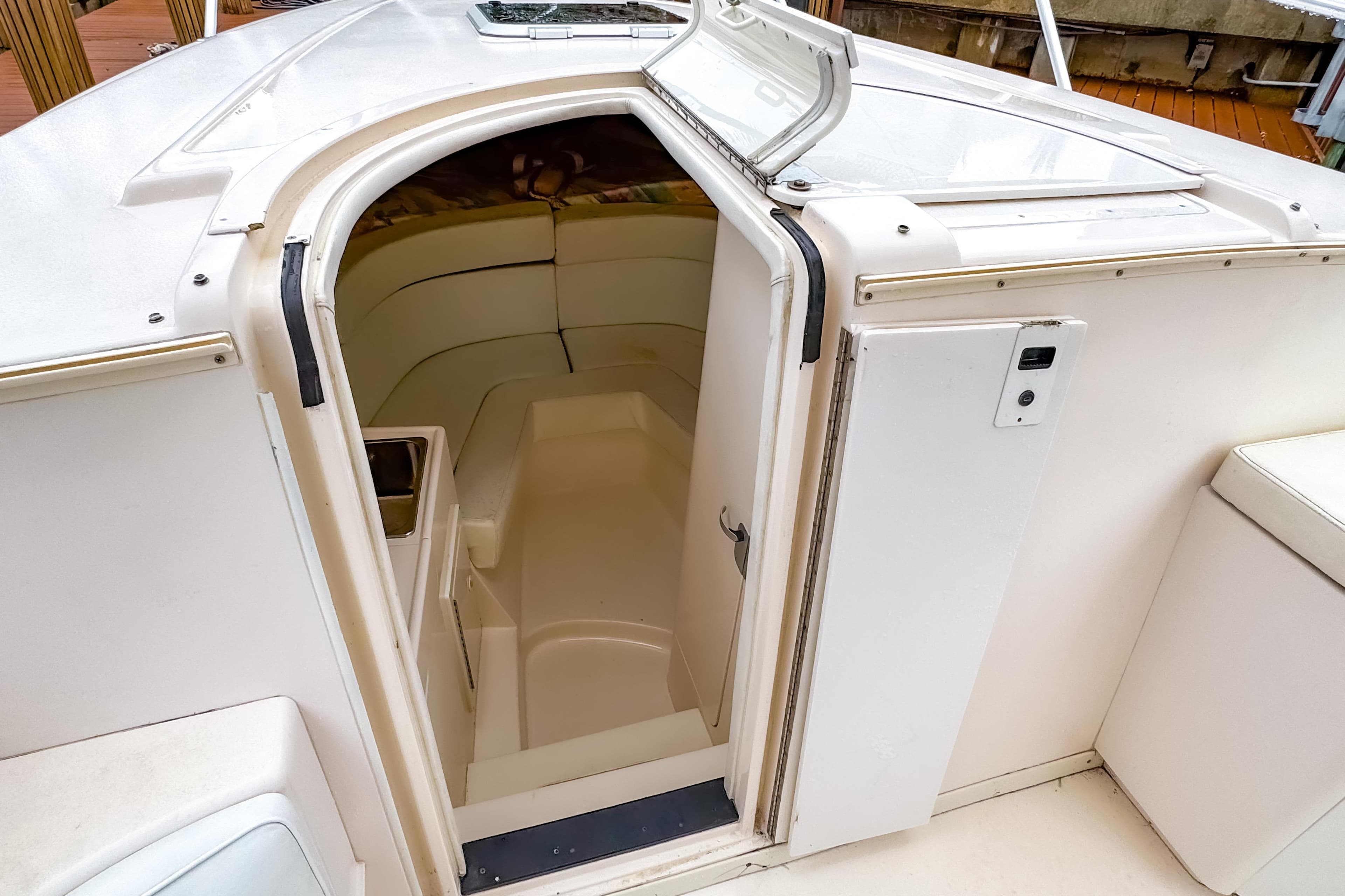 1998 Intrepid 356 Cuddy cabin entrance, featuring sleek white interior and compact design.