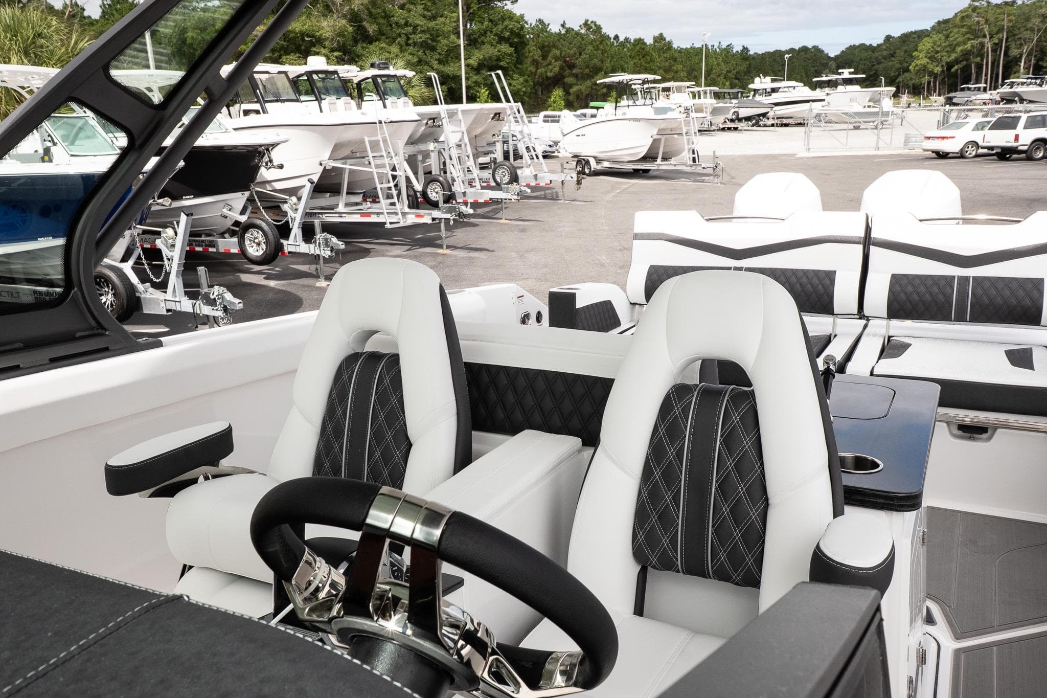 Interior of 2026 Monterey Elite 30 OB boat with luxurious seating and steering wheel.