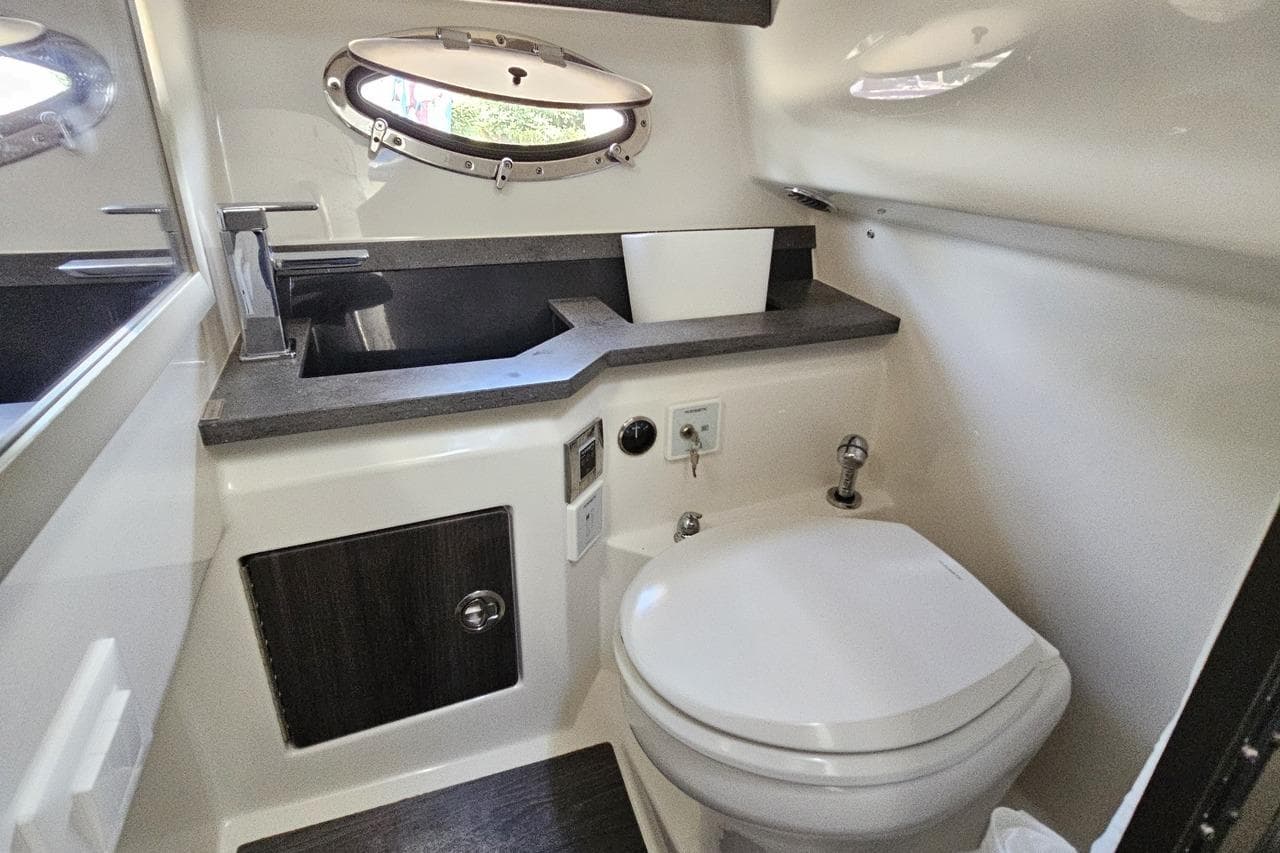 2020 Formula 330 Crossover Bowrider bathroom with modern fixtures and porthole window.
