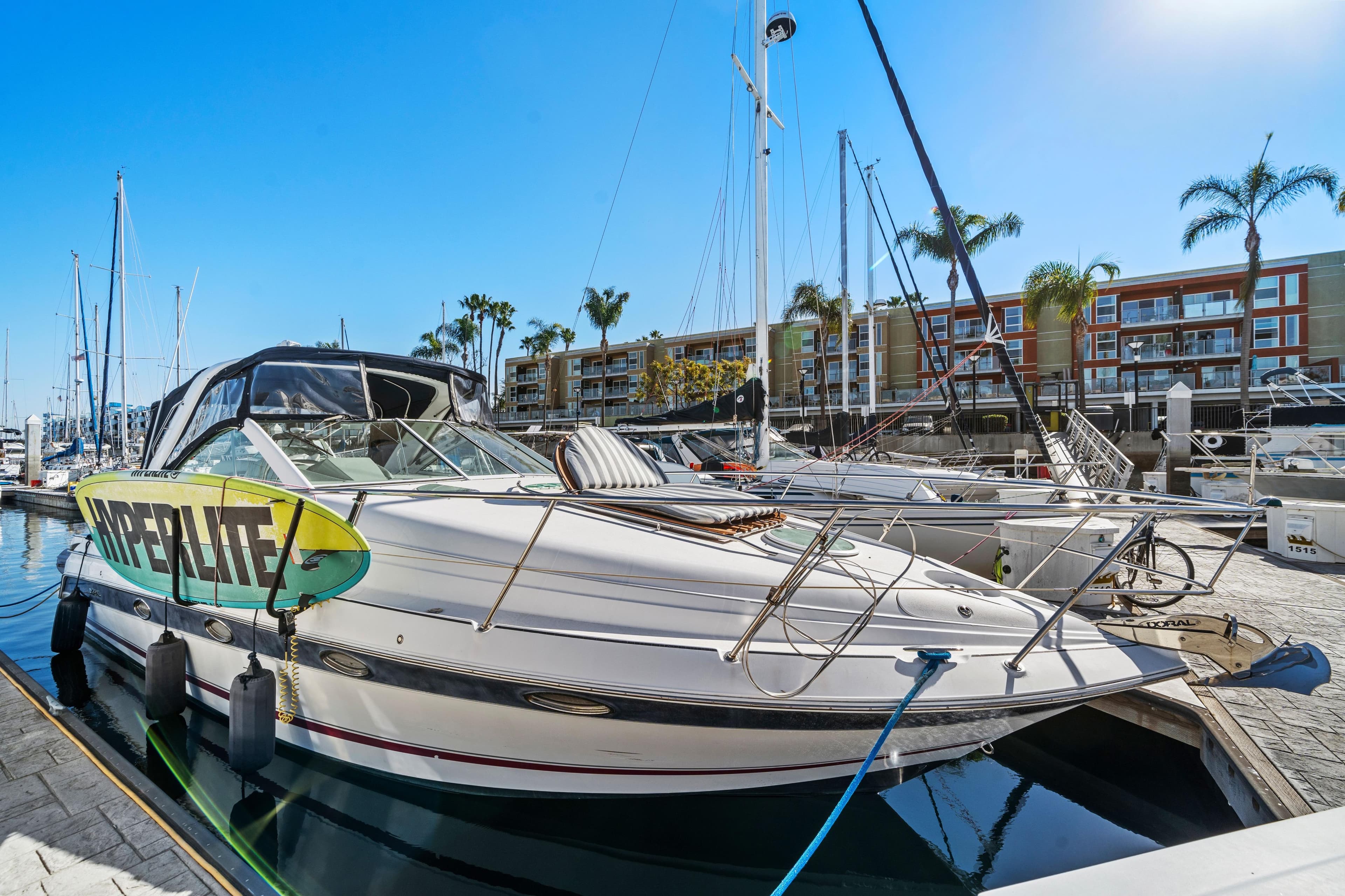 2005 Doral 360se boat docked at marina with wakeboard, palm trees, and clear sky.