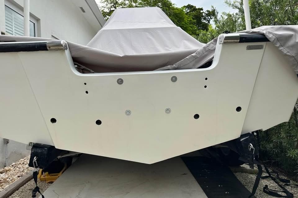 1992 Boston Whaler 19 Outrage boat with cover, rear view, parked outdoors.