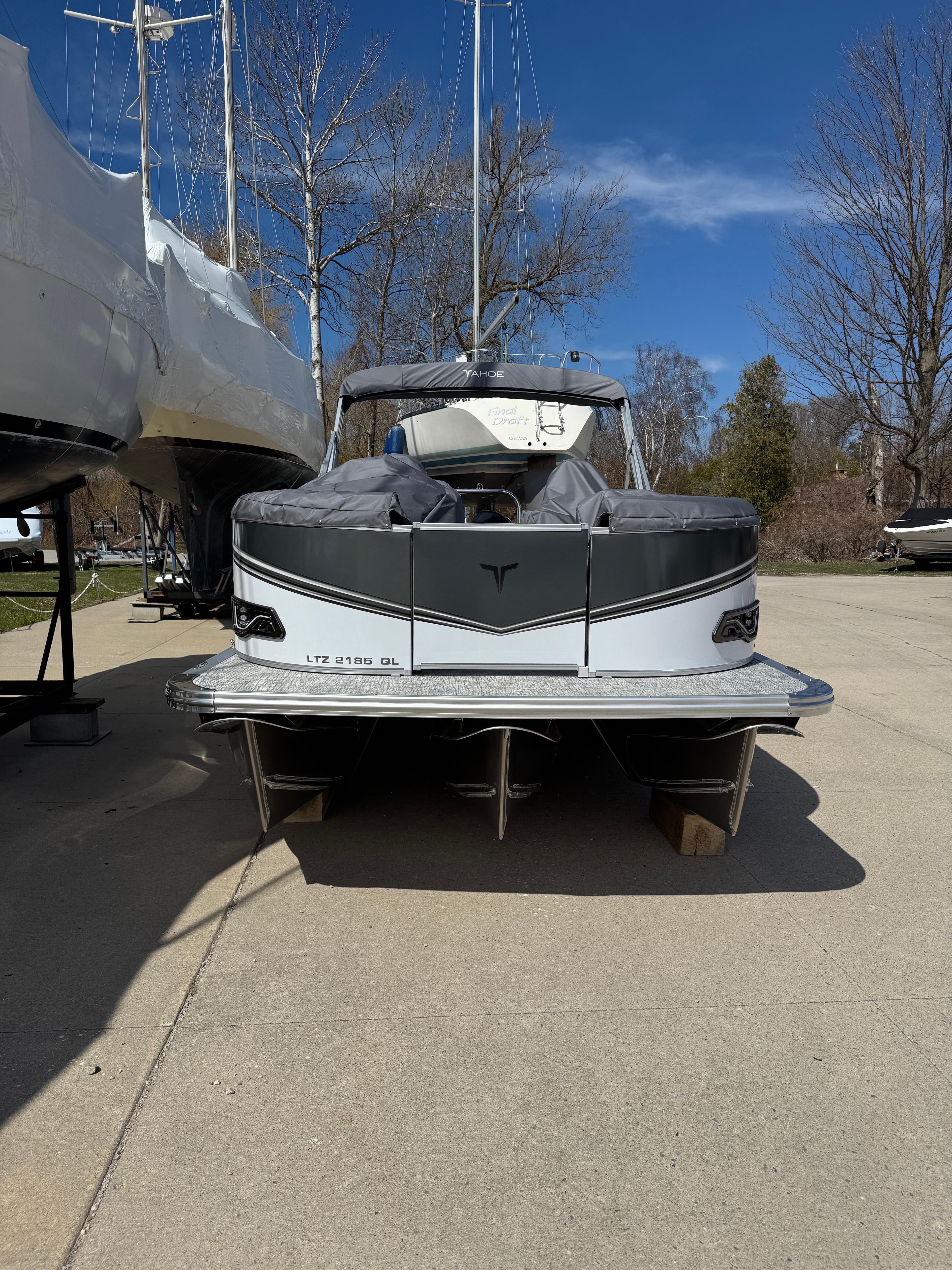2025 Tahoe Pontoon LTZ Quad Lounger on a sunny day, parked on concrete.