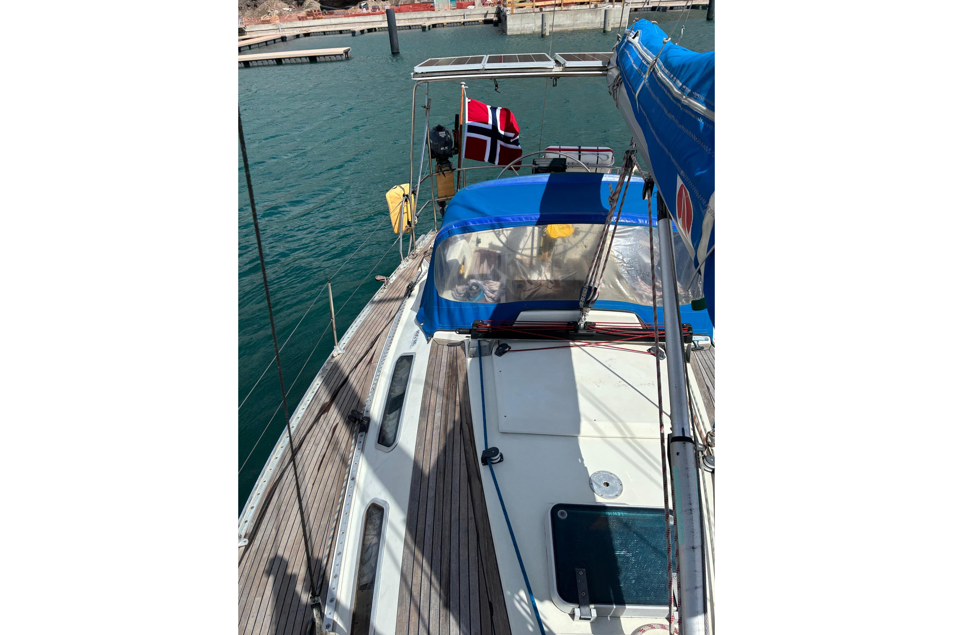 1989 Sweden Yachts 340 sailboat docked, featuring a blue canopy and Norwegian flag.