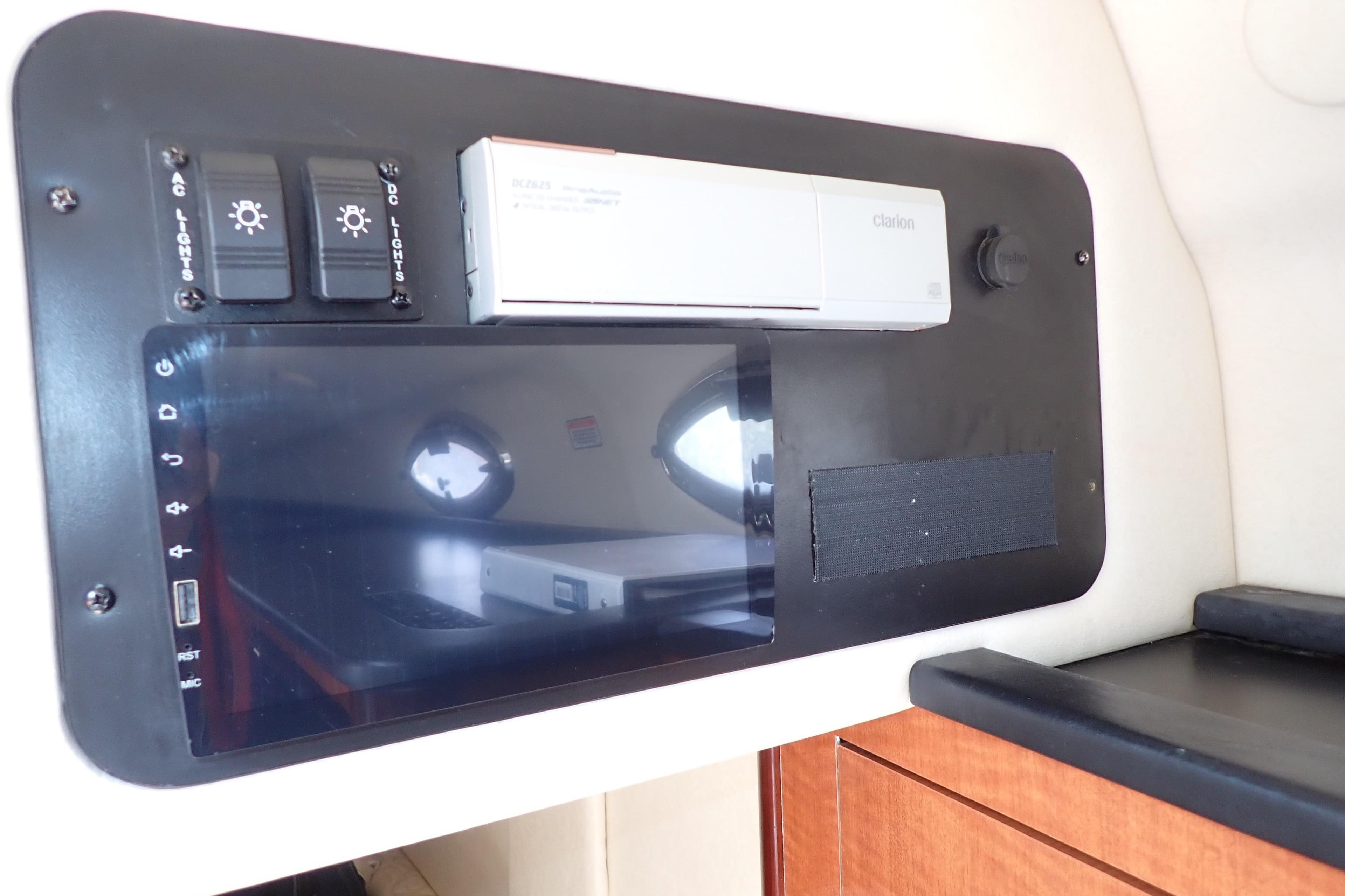 Control panel inside 2005 Sea Ray Sundancer 260 boat, featuring switches and a Clarion unit.