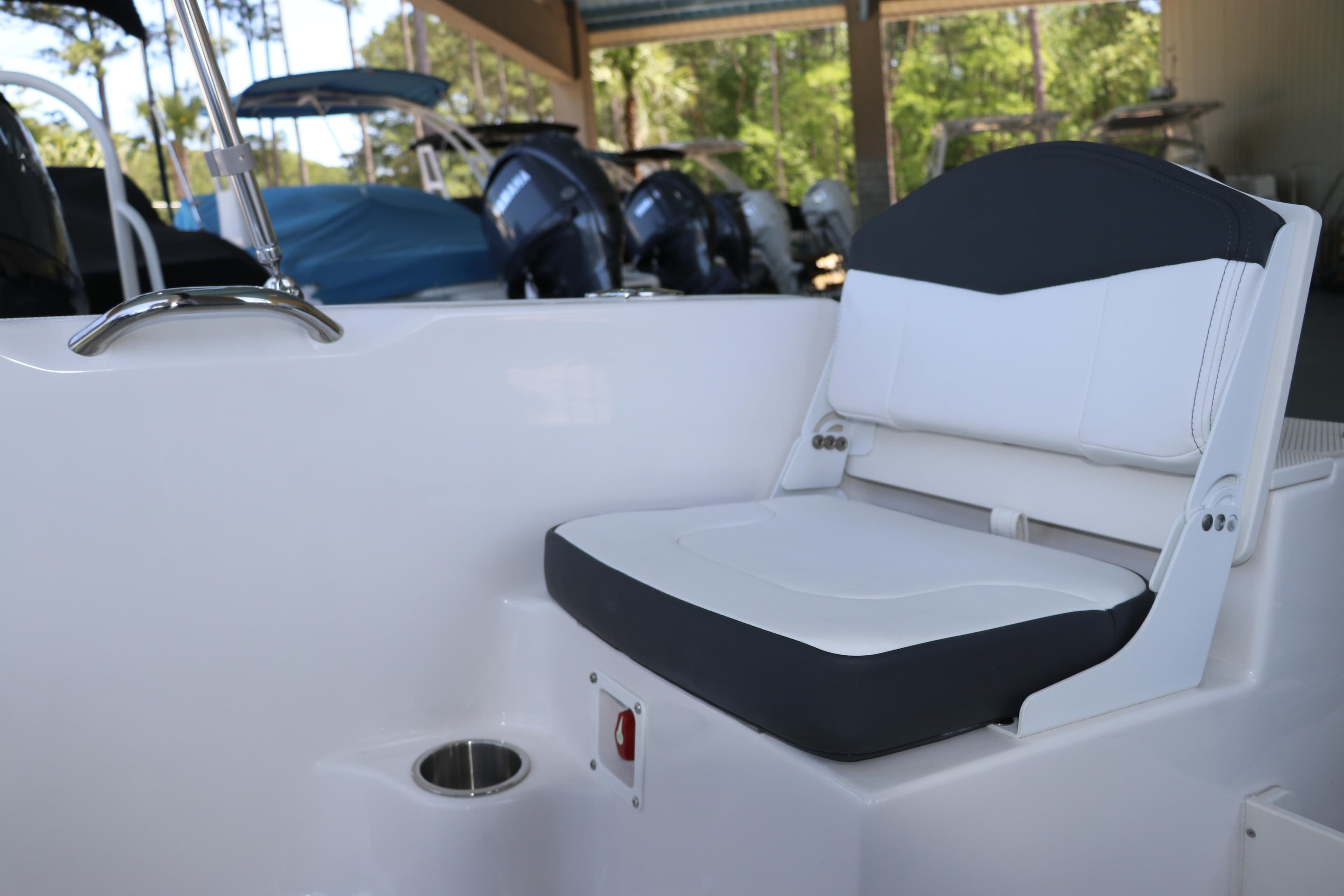 2026 Robalo R160 Center Console boat seat with cup holder, in a marina setting.