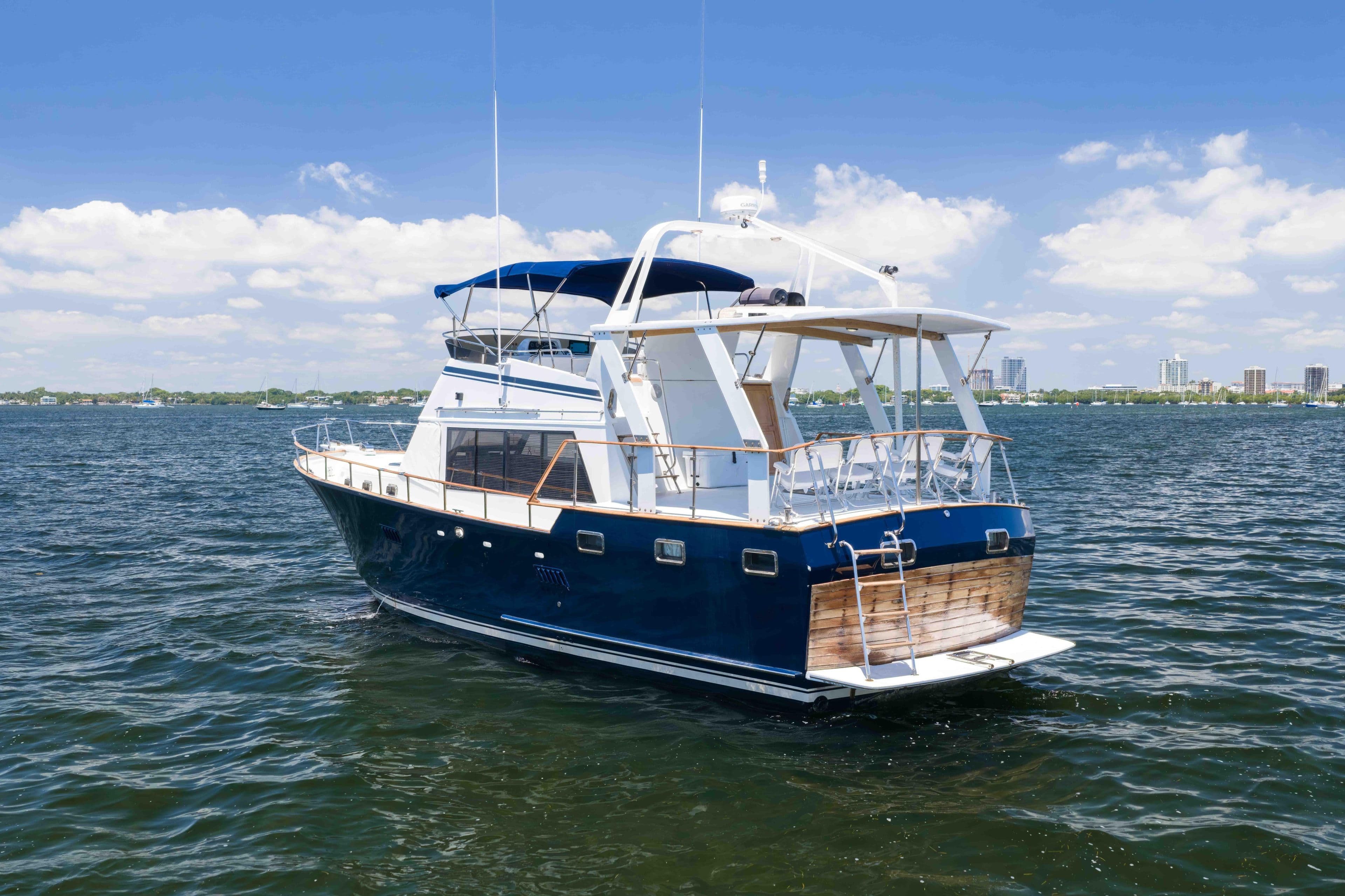 1983 Sea Ranger 45 Sundeck yacht on calm water under a clear blue sky.