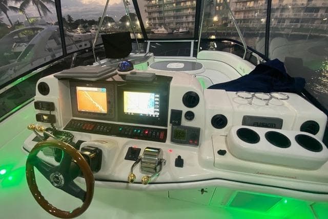 2007 Sea Ray 52 Sedan Bridge helm with illuminated controls and navigation screens at dusk.