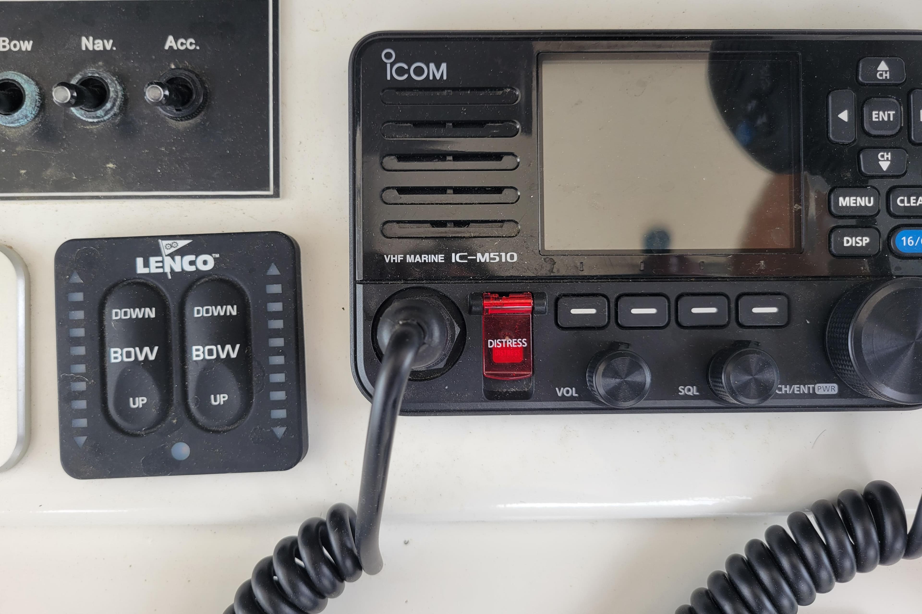 Control panel of a 1979 Bertram 38 Convertible with Icom VHF radio and Lenco trim tab switches.