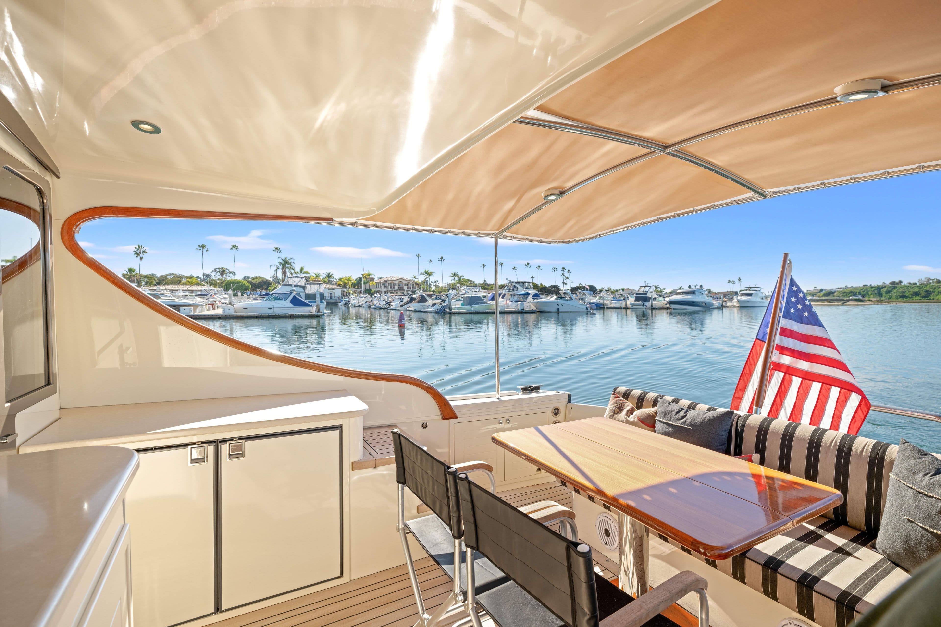 Luxurious 2015 Palm Beach Motor Yachts PB45 interior with marina view and American flag.