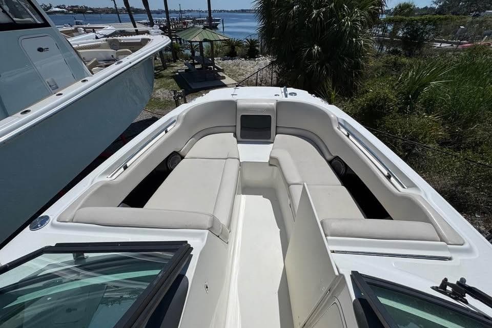 2015 Boston Whaler 230 Vantage boat interior with cushioned seating and scenic waterfront view.