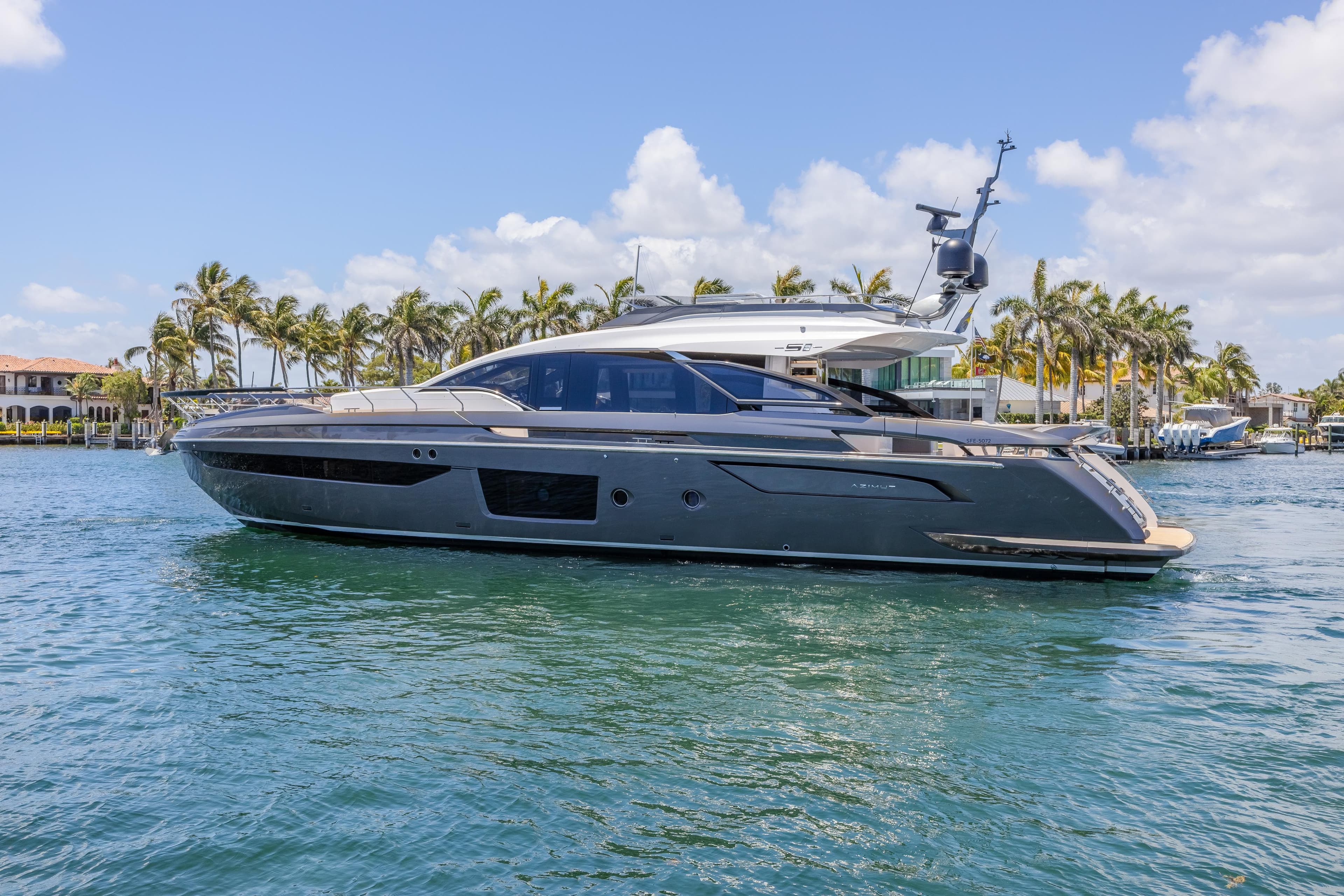 2023 Azimut S8 yacht cruising on a sunny day with palm trees in the background.