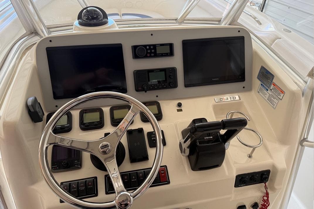 2007 Pursuit C 310 Center Console boat dashboard with steering wheel and navigation controls.