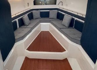 Interior seating area of 2017 Evo Yachts 43 with blue cushions and wooden flooring.