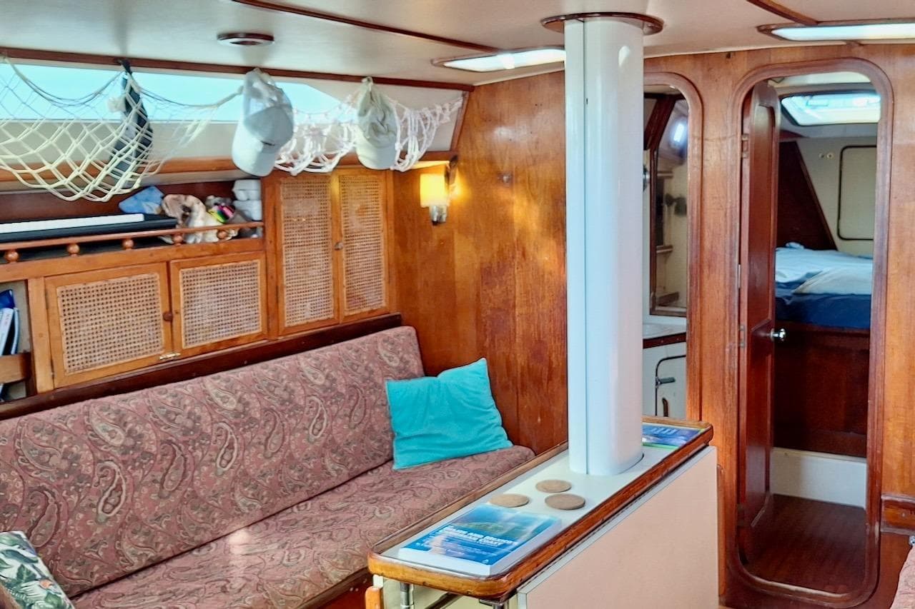 Interior of 1985 Gulfstar Hirsch 45 CC sailboat with cozy seating and wooden cabinetry.