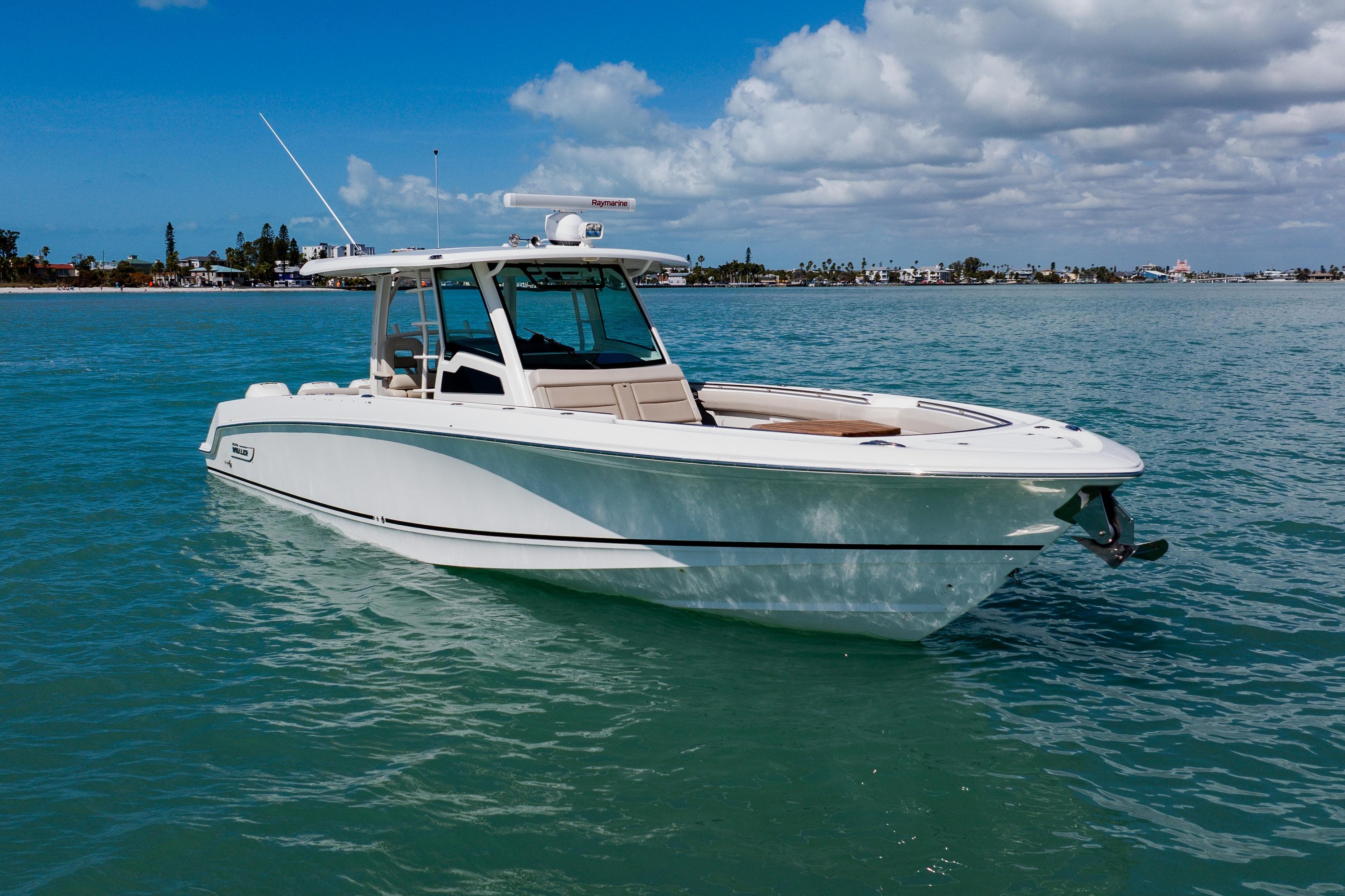 2019 Boston Whaler 380 Outrage boat on calm blue water under a partly cloudy sky.