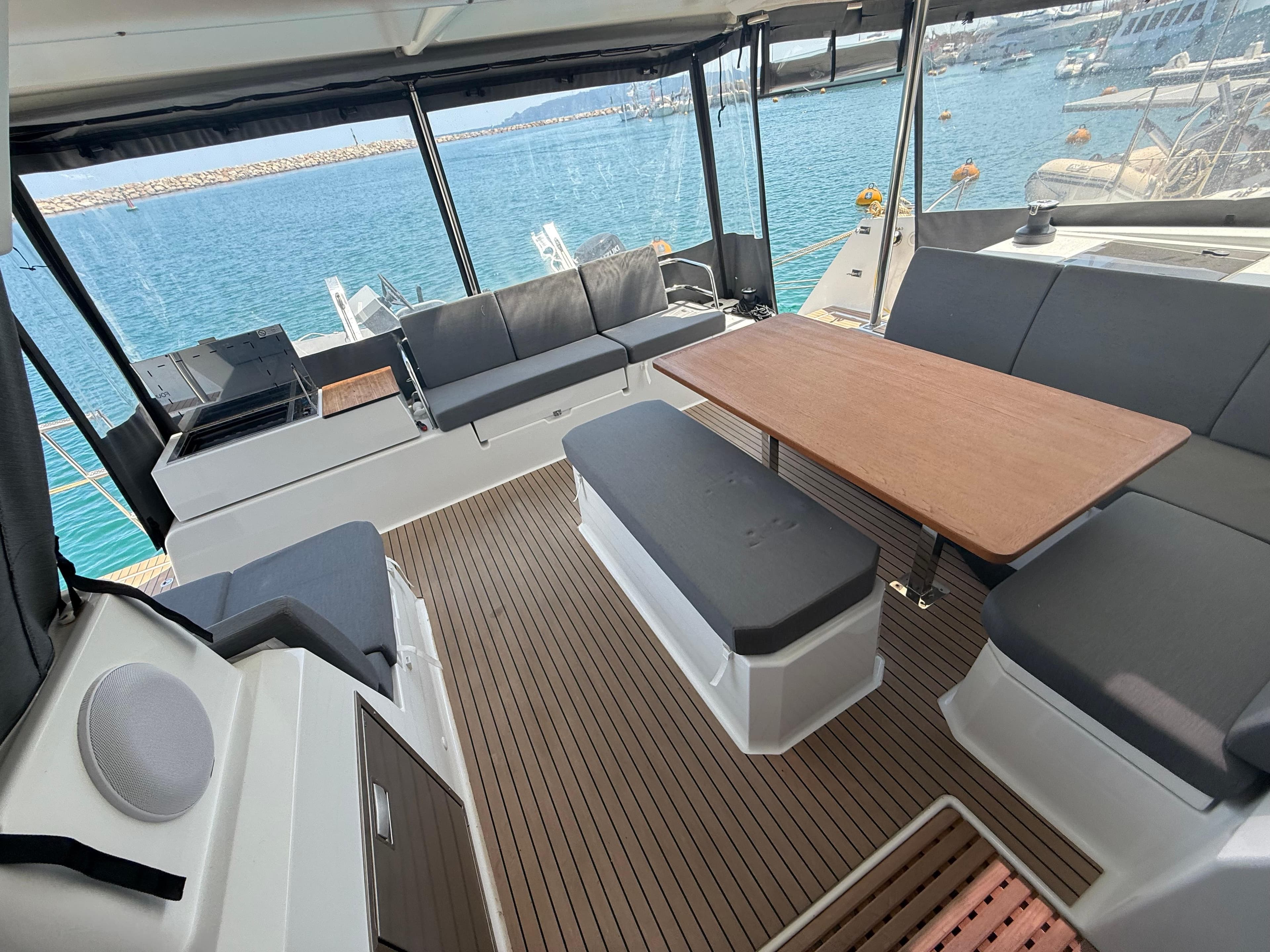 Spacious deck of 2022 Fountaine Pajot Astrea 42 catamaran with seating and table.
