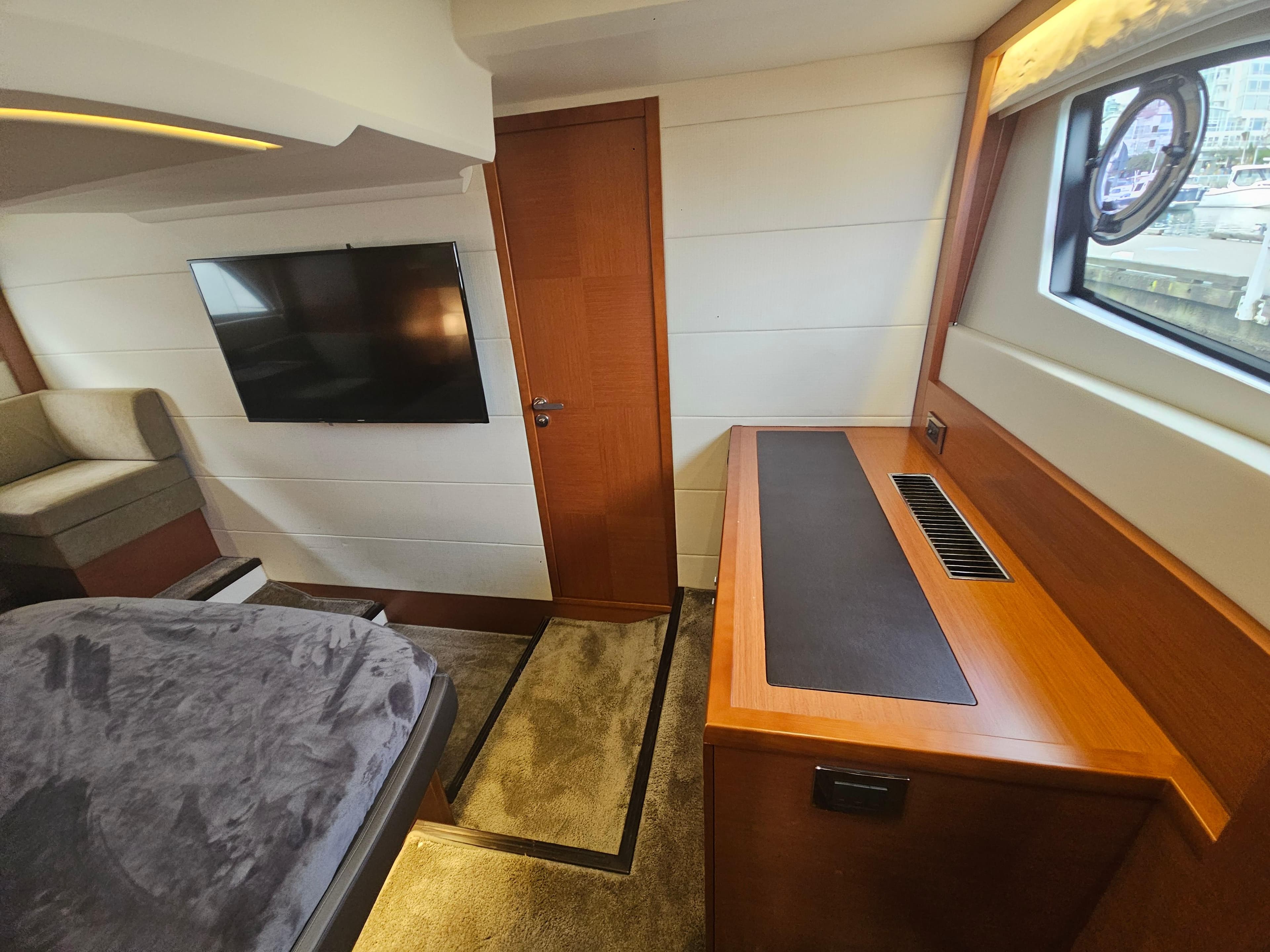 Luxurious interior of a 2016 Prestige 500 S yacht with modern furnishings and a flat-screen TV.