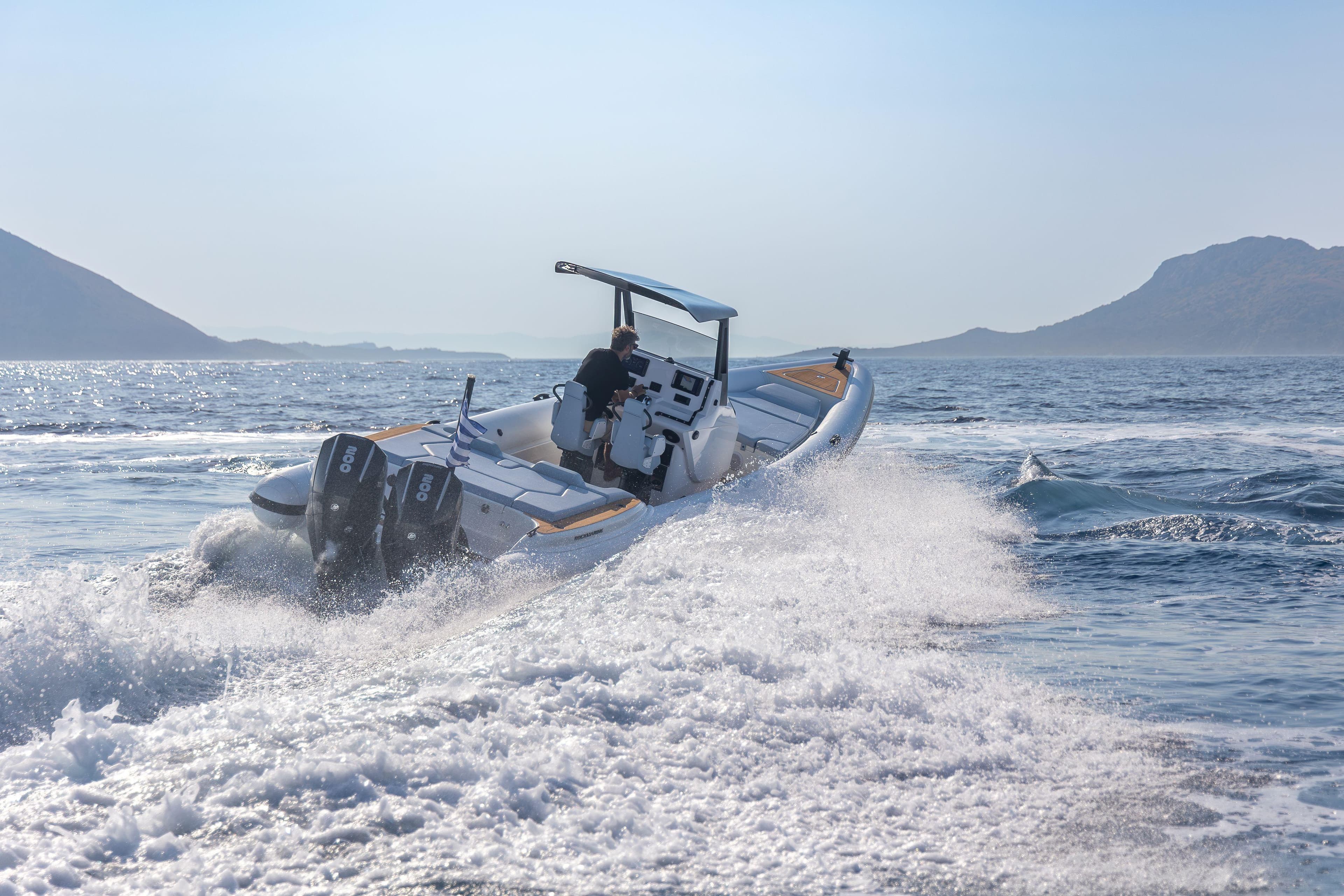 2026 Rock Marine RM 30 speedboat cruising on open water with scenic mountain backdrop.