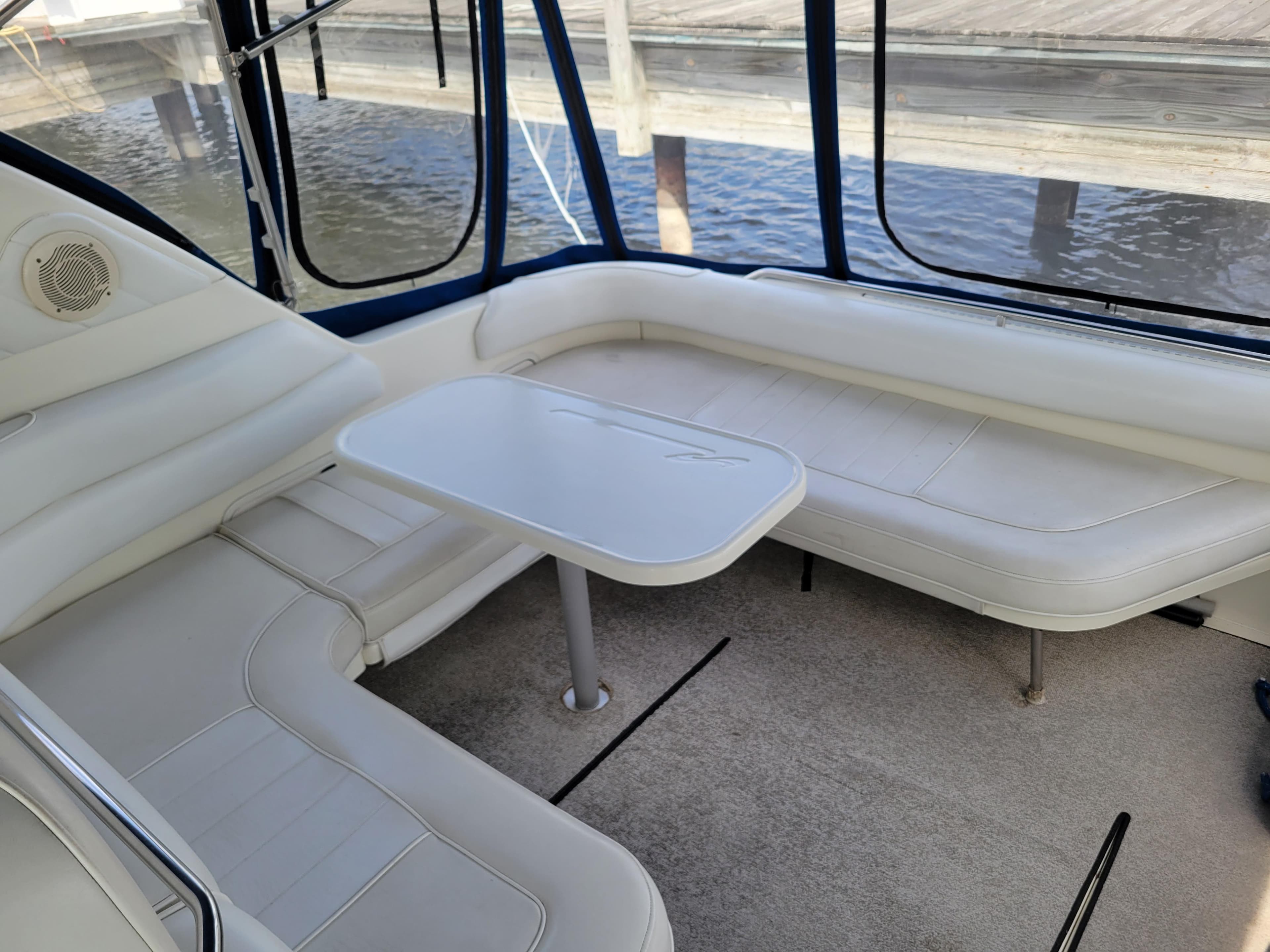 1995 Sea Ray 370 Sundancer interior with white seating and table, dockside view.