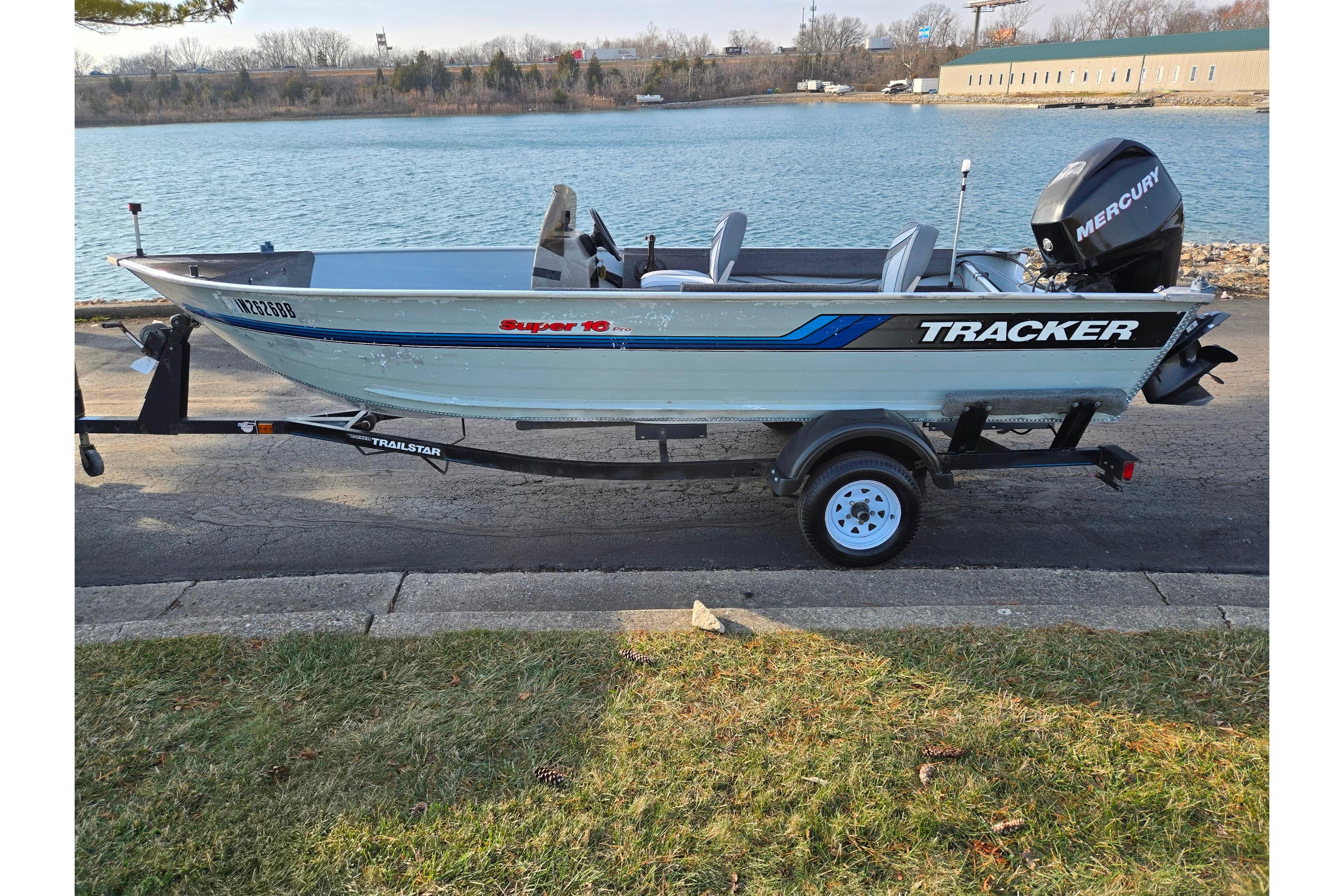 1994 Tracker Pro Deep V-16 boat with Mercury engine on trailer by a lake.
