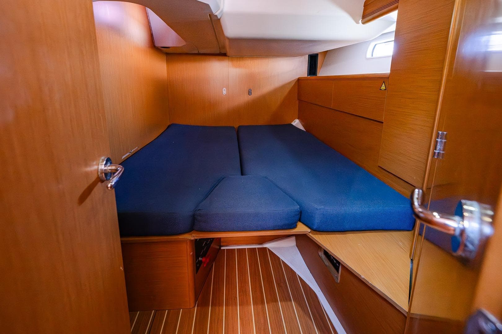 2010 Jeanneau 53 yacht cabin with blue bedding and wooden interior.