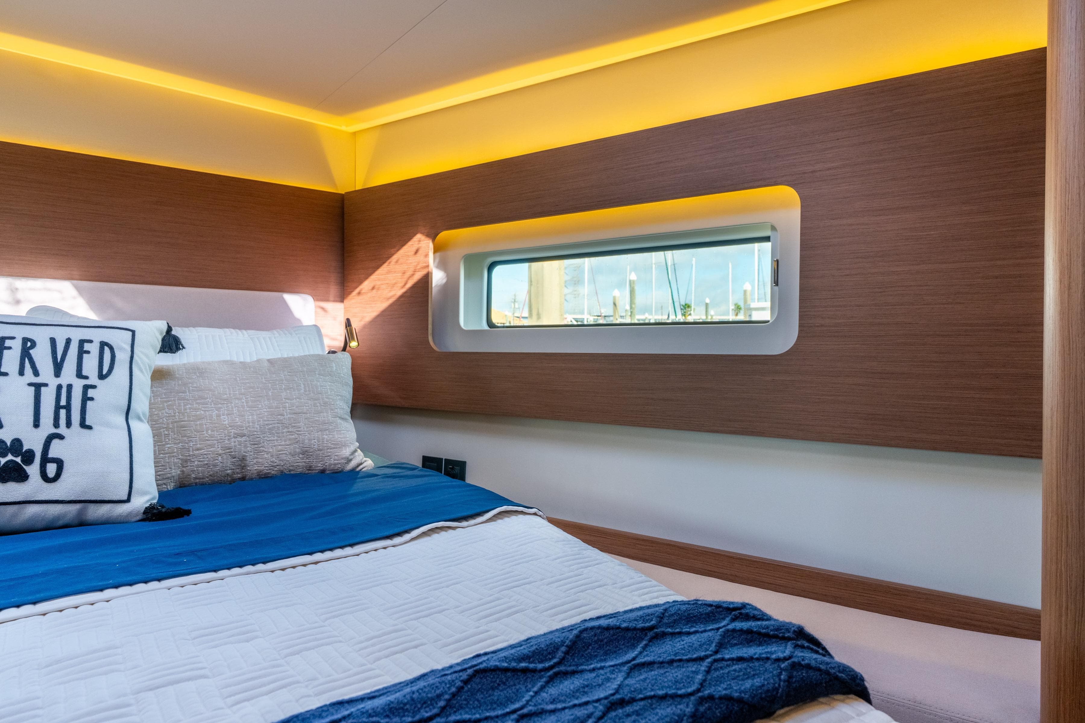 Luxurious cabin interior of 2021 Beneteau Oceanis Yacht 54 with modern design and cozy bedding.