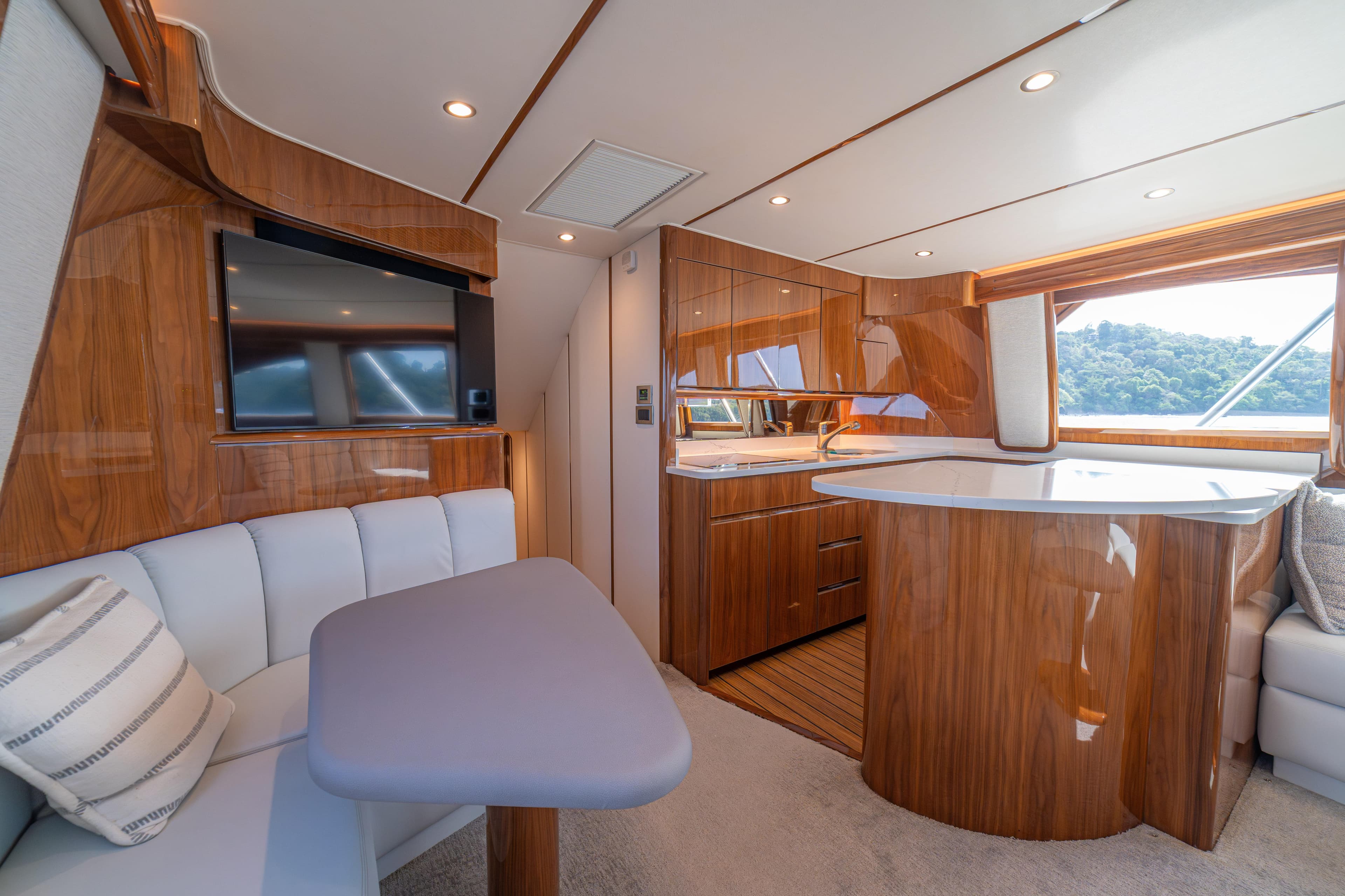 Luxurious interior of 2024 Viking 48 Convertible yacht with modern wood finishes and seating area.