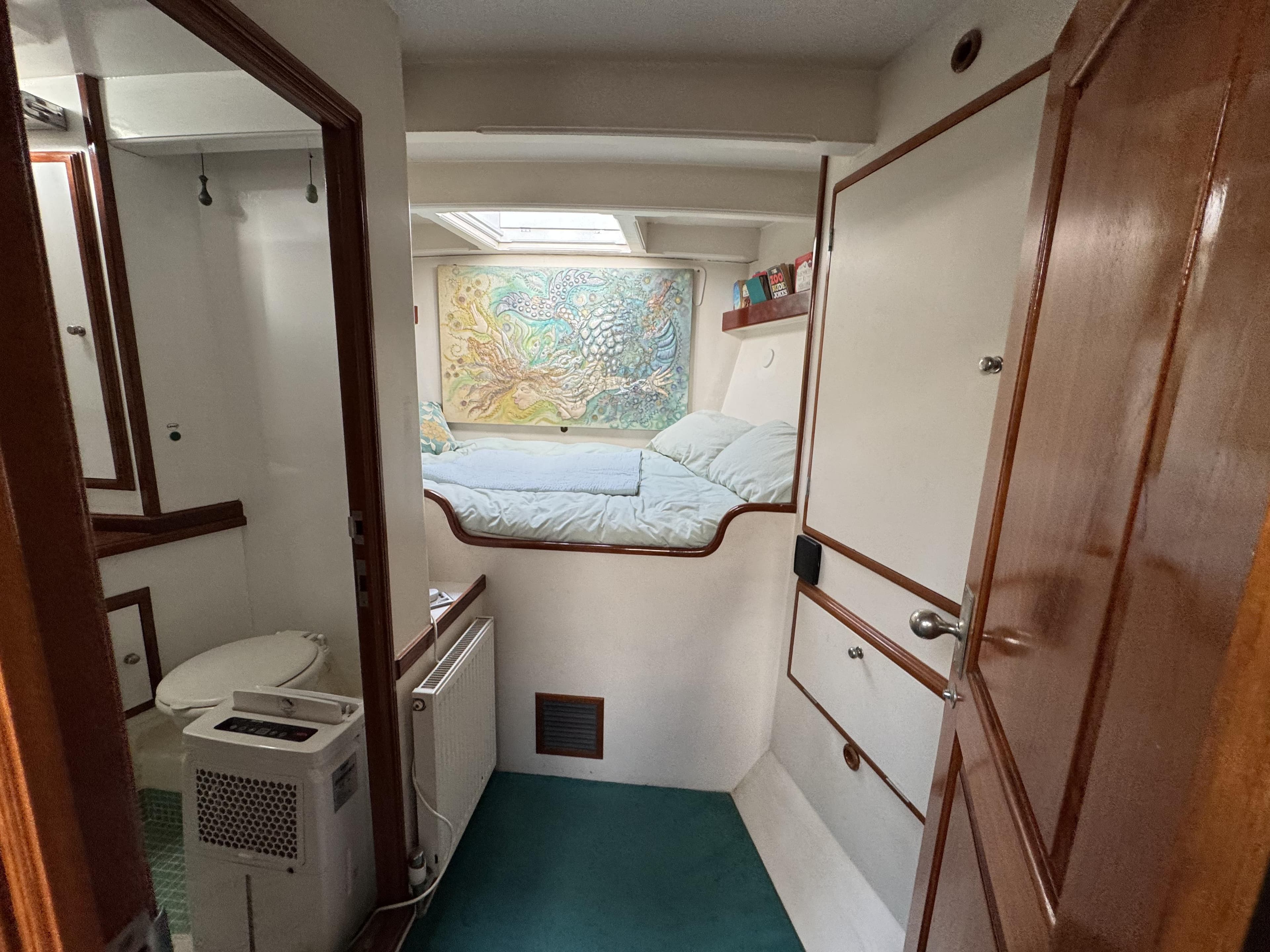 Cozy cabin interior of 2012 Classic 65ft Ketch Pilot House with bed and map decor.