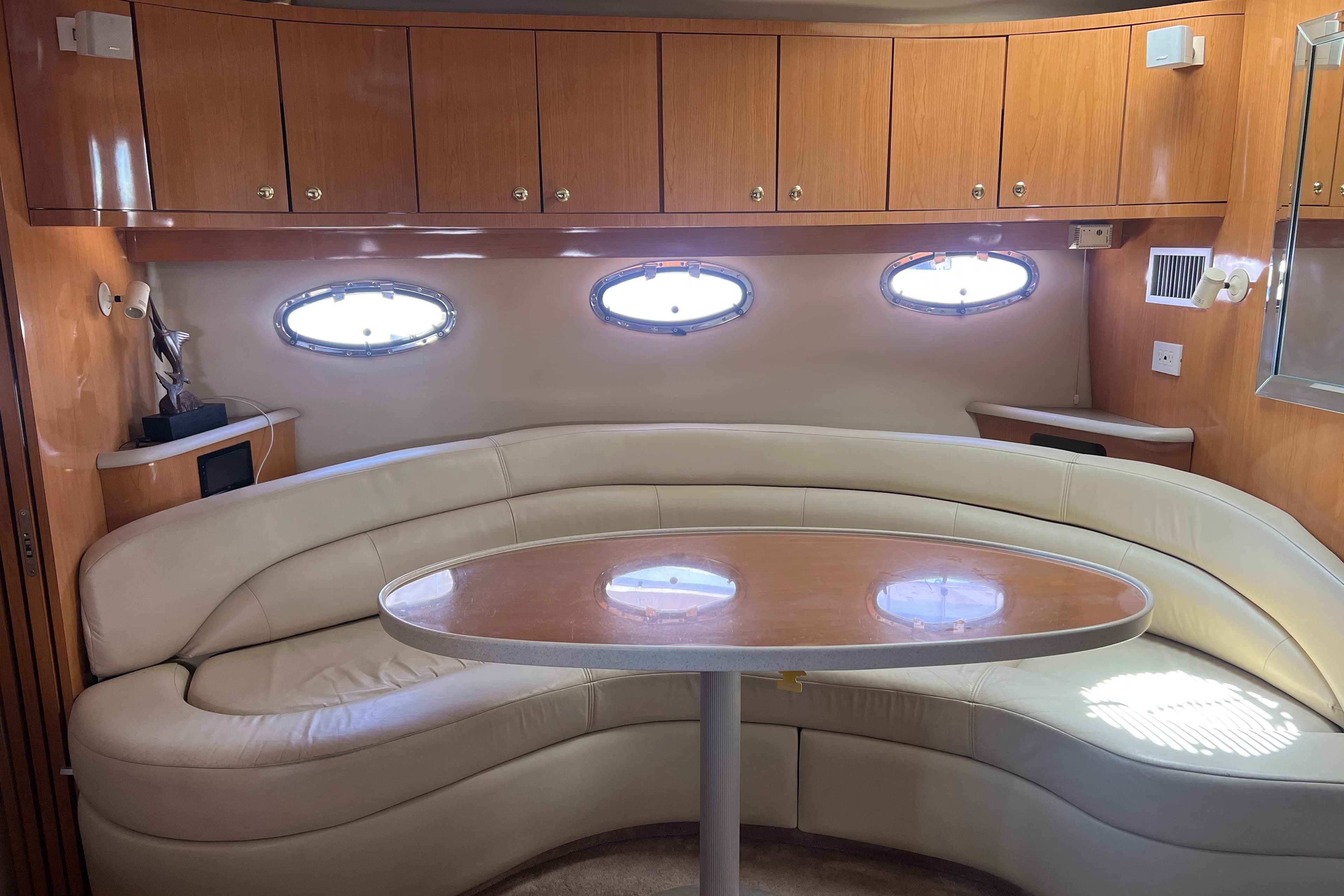 Interior of 2000 Regal Commodore 4160 yacht with curved seating and wooden cabinetry.