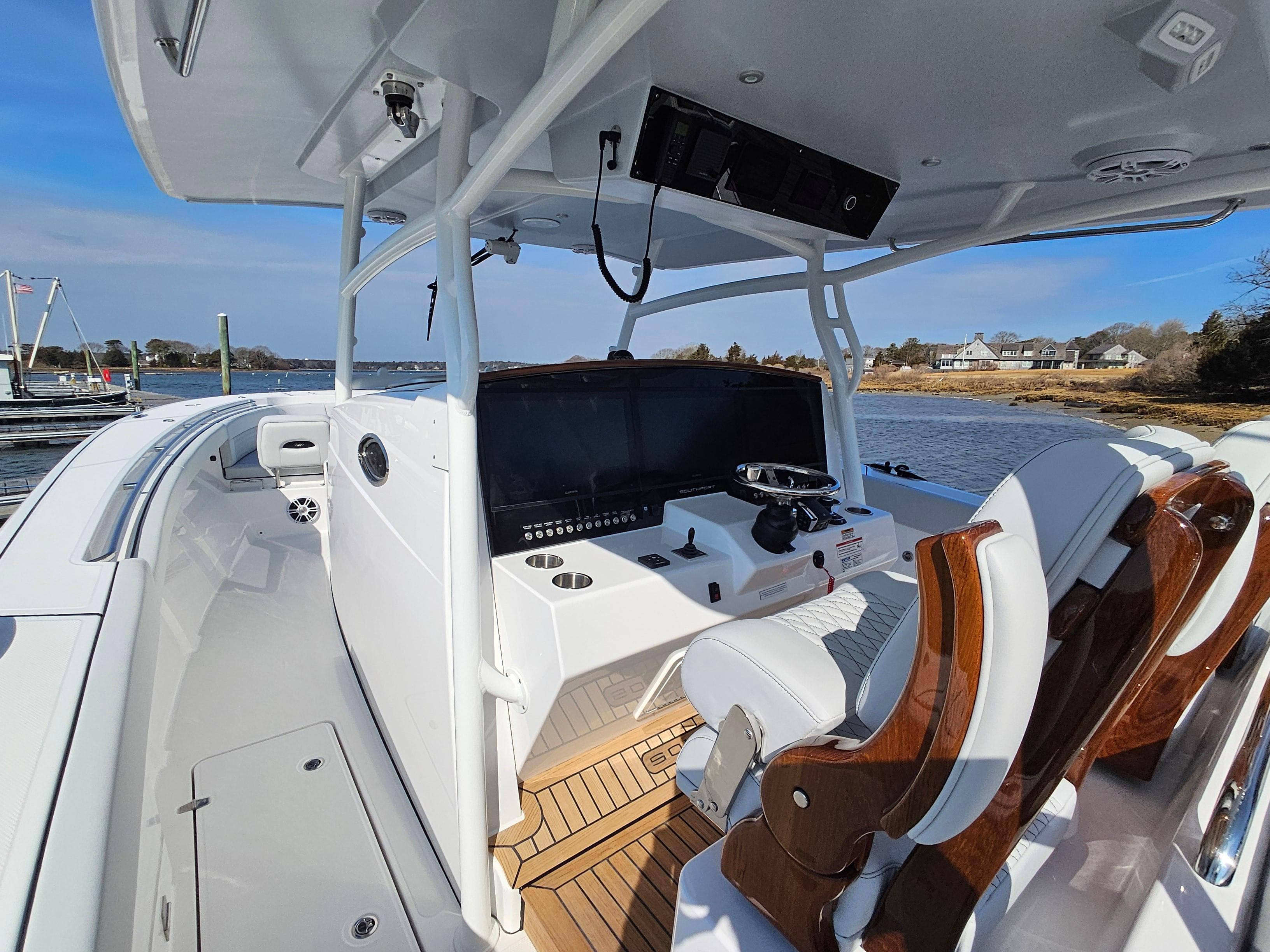 2025 Southport 38 FE boat interior with helm, wooden seats, and water view.