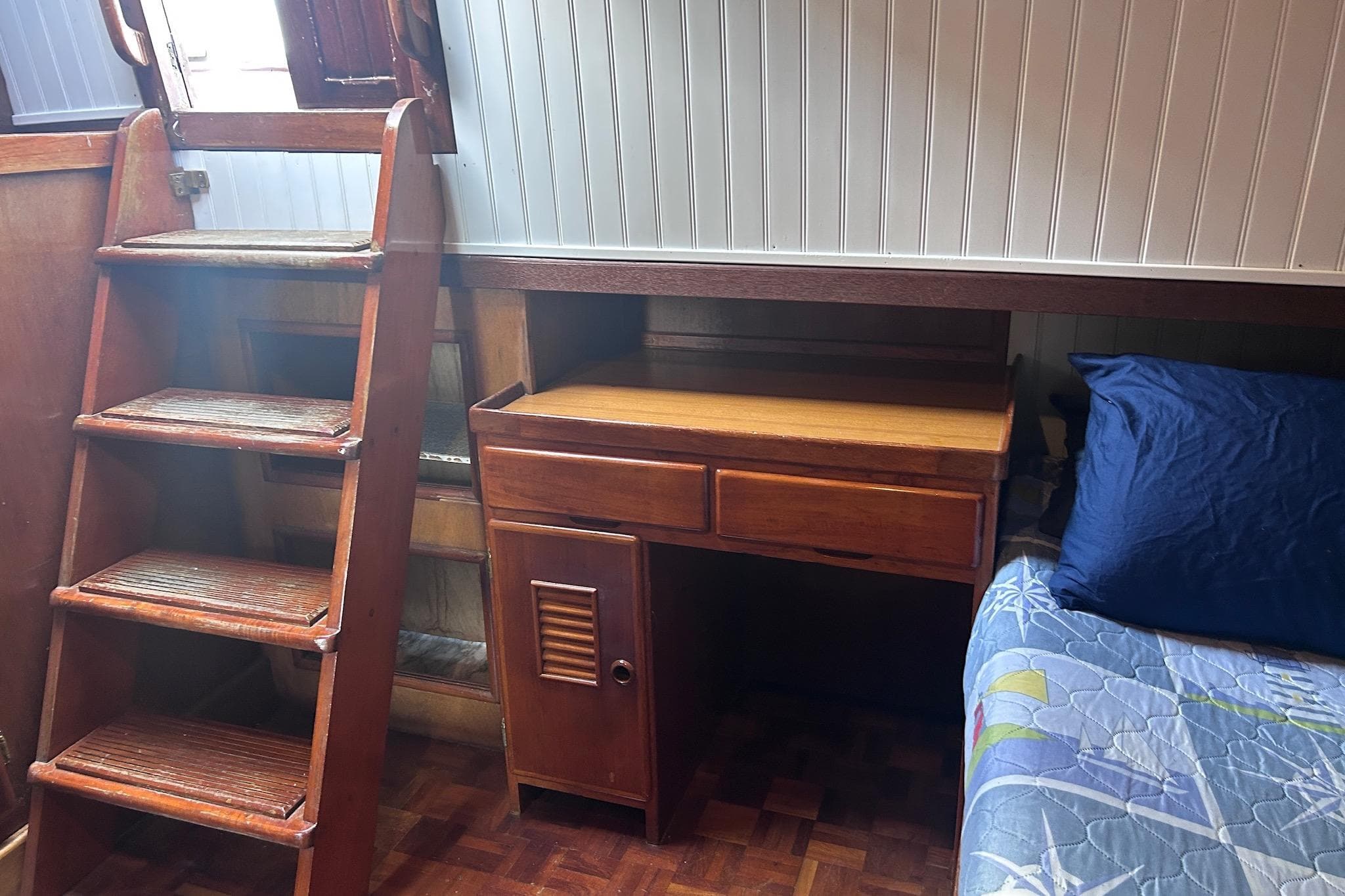 1977 Marine Trader 40 Double Cabin interior with wooden stairs, desk, and bed.