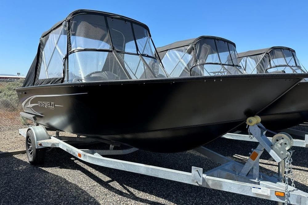 2022 Starweld Flex Pro 19 DC boat on trailer, black exterior, clear canopy.