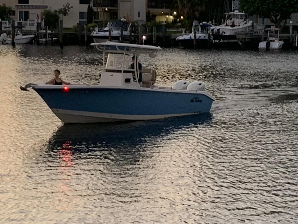 2019 Sea Chaser 27 HFC boat cruising on calm waters at dusk.