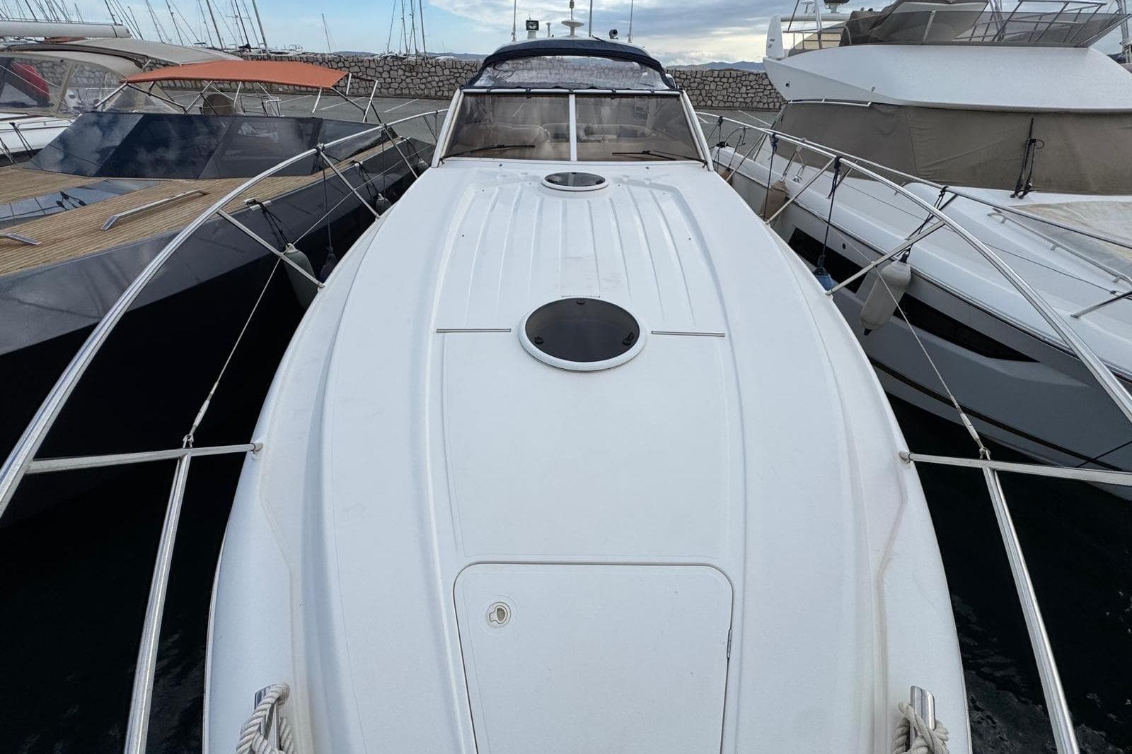 2002 Princess V42 yacht docked among other boats in a marina.