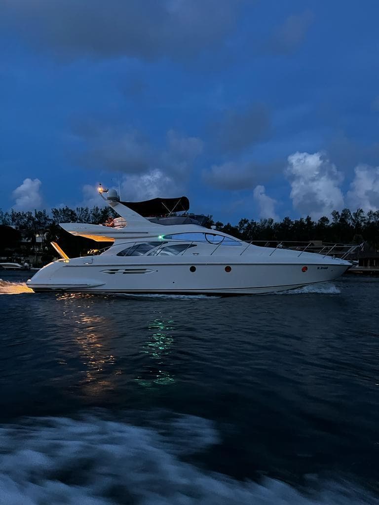 2008 Azimut Flybridge yacht cruising at dusk on calm waters.