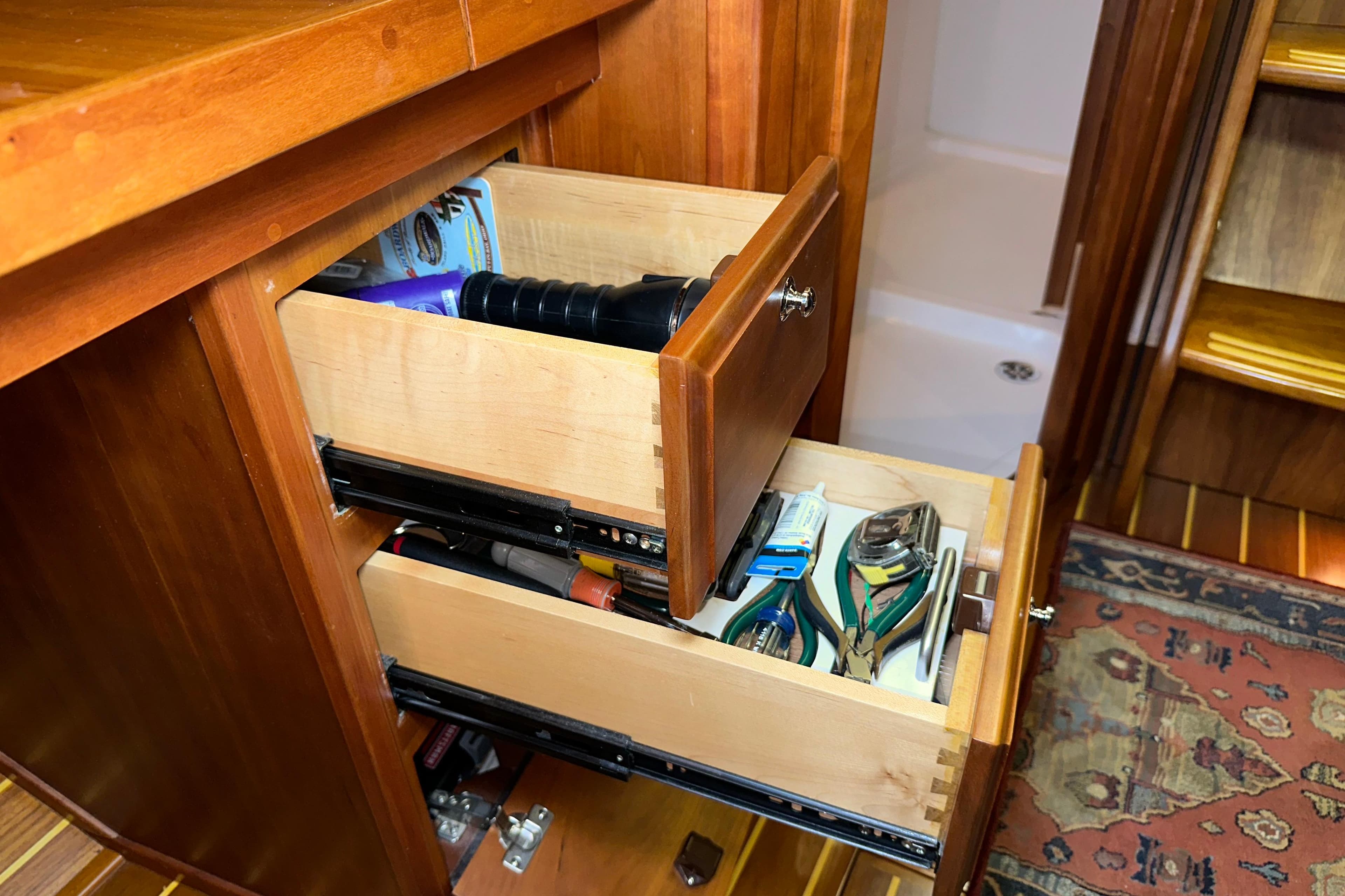 Wooden drawers in a 2007 Sabre 386 yacht, containing tools and accessories.
